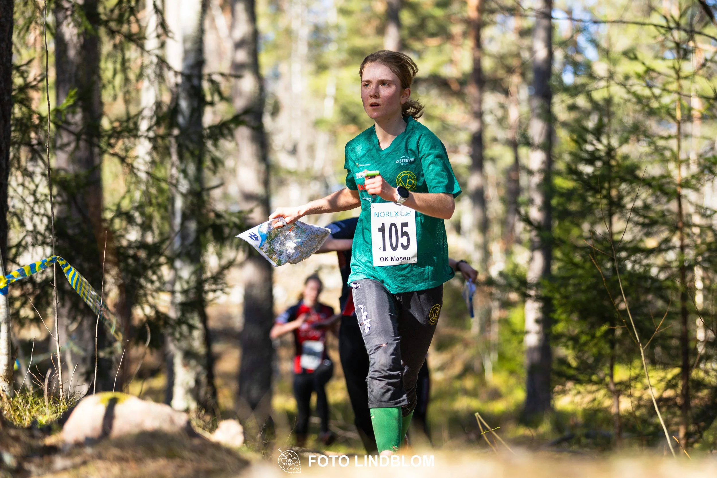 An image from the orienteering relay Måsenstafetten 2026, showing athletes in forest terrain, showing Tuva Östangård, shot by Foto Lindblom.