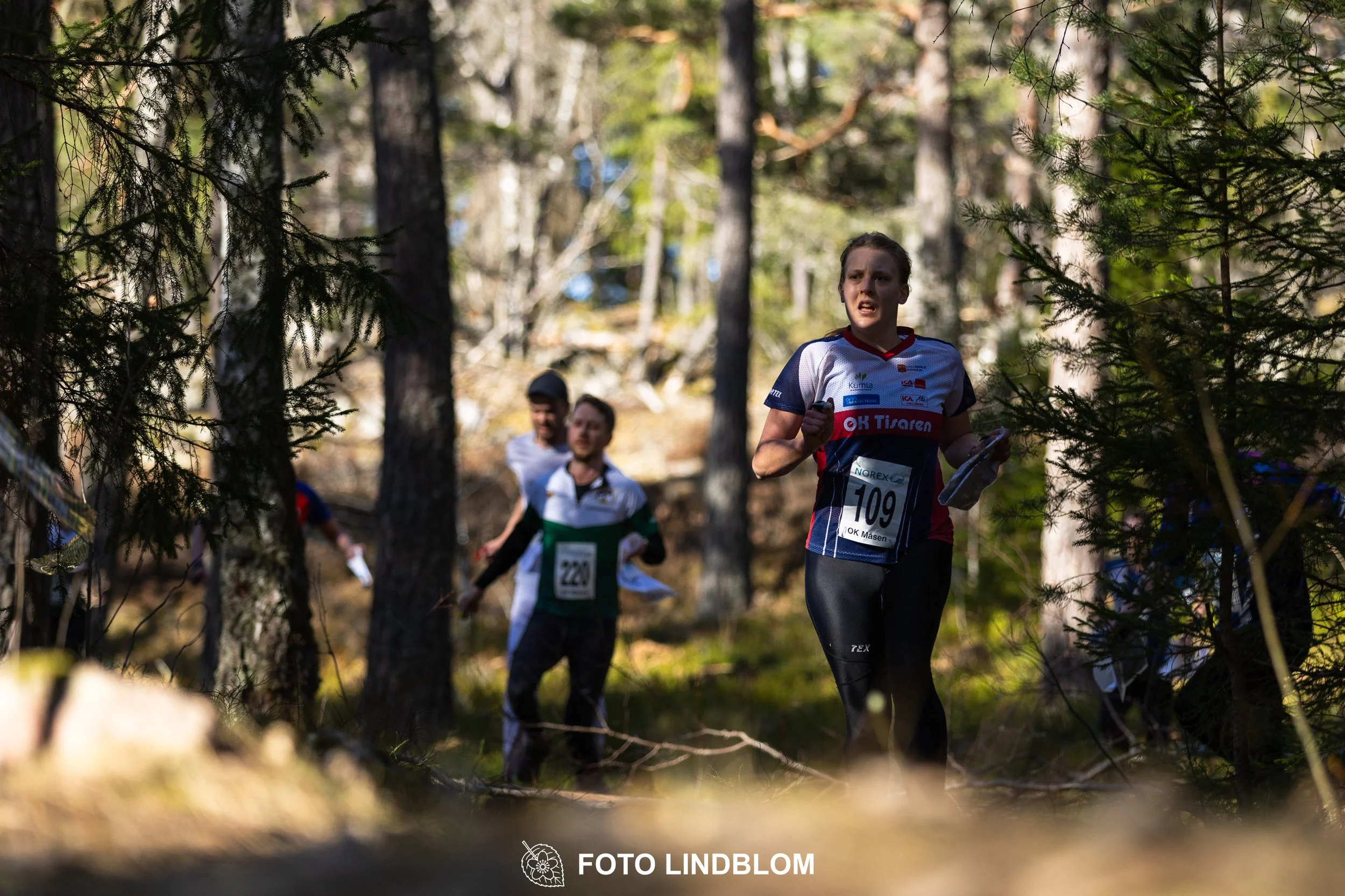 Orienteering relay race at Måsenstafetten 2026, featuring club teams navigating with map and compass, captured by Foto Lindblom.