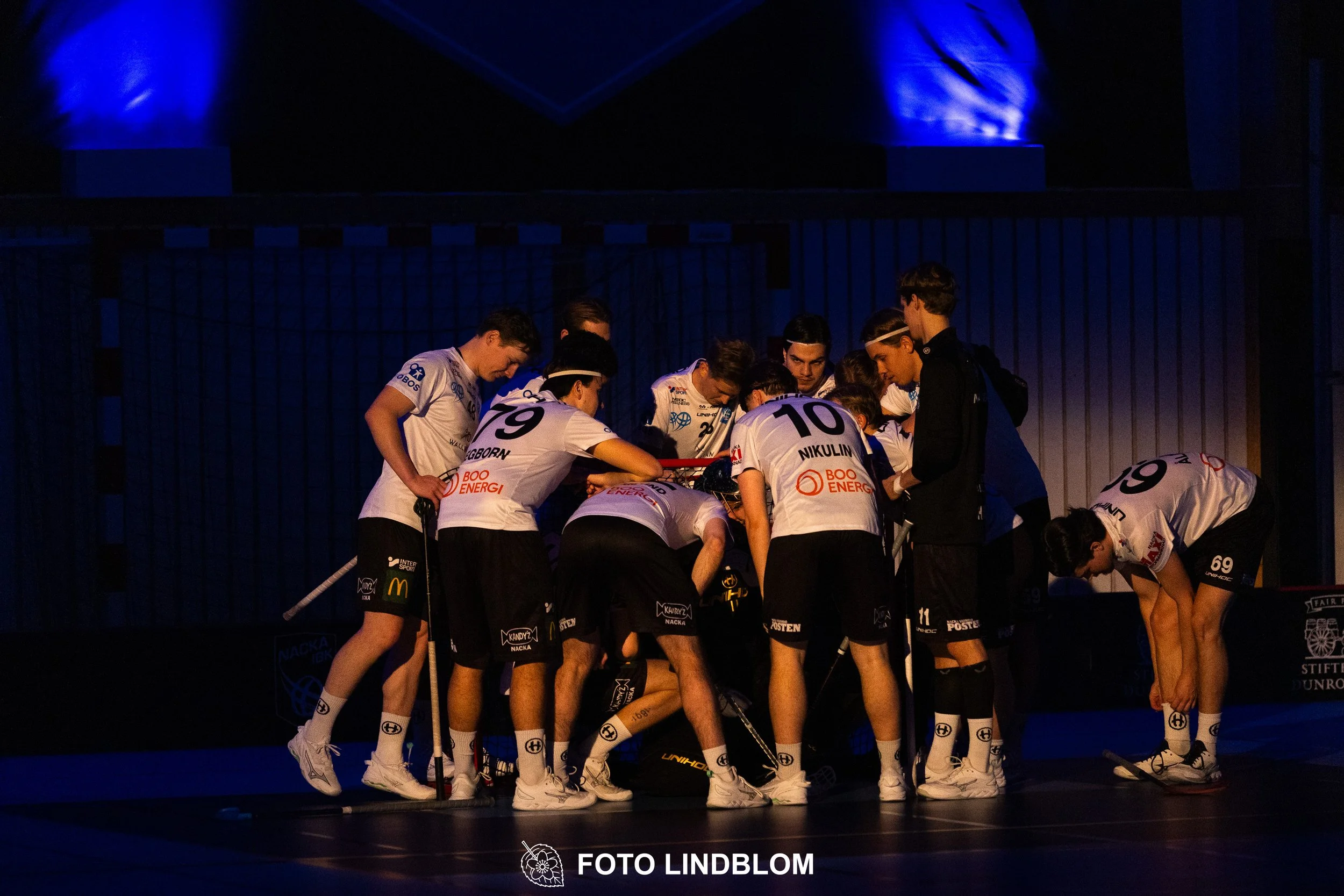 A picture of men playing floorball in Nacka IBK and FBC Sollentuna team gear