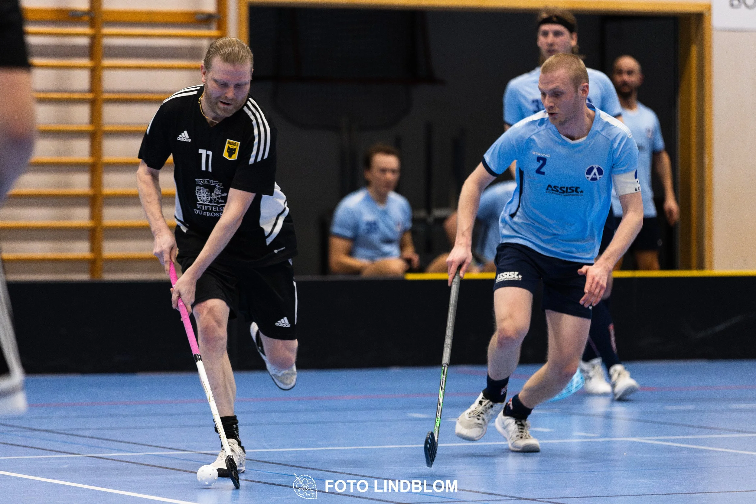 A picture of men playing floorball in Ingarö IF and Älvsjö AIK IBF team gear