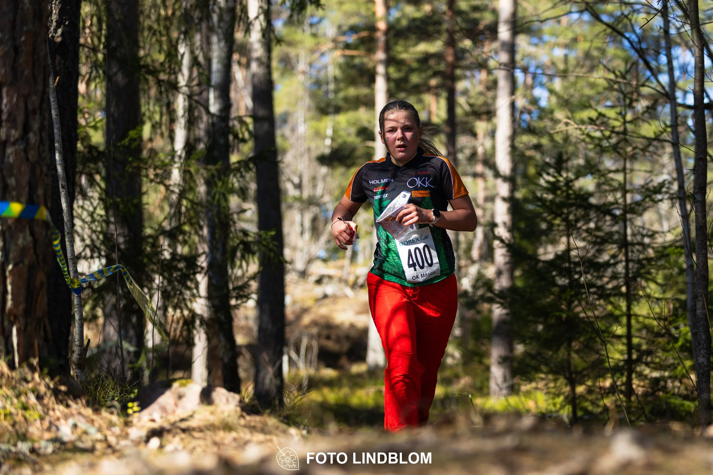 Swedish orienteering relay event Måsenstafetten 2026, with teams racing through forest terrain, captured by Foto Lindblom.