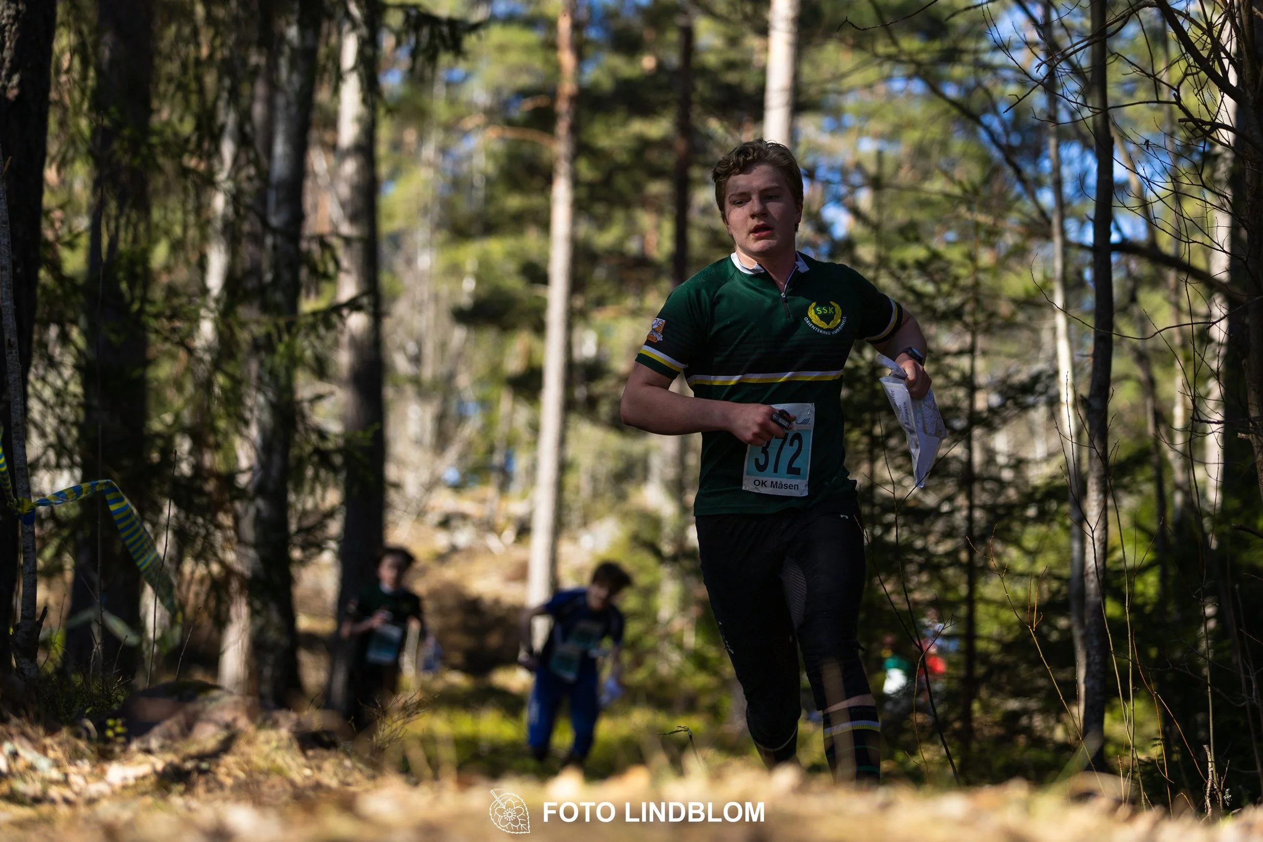 Team relay action at Måsenstafetten 2026, an orienteering competition in forest terrain, photographed by Foto Lindblom.