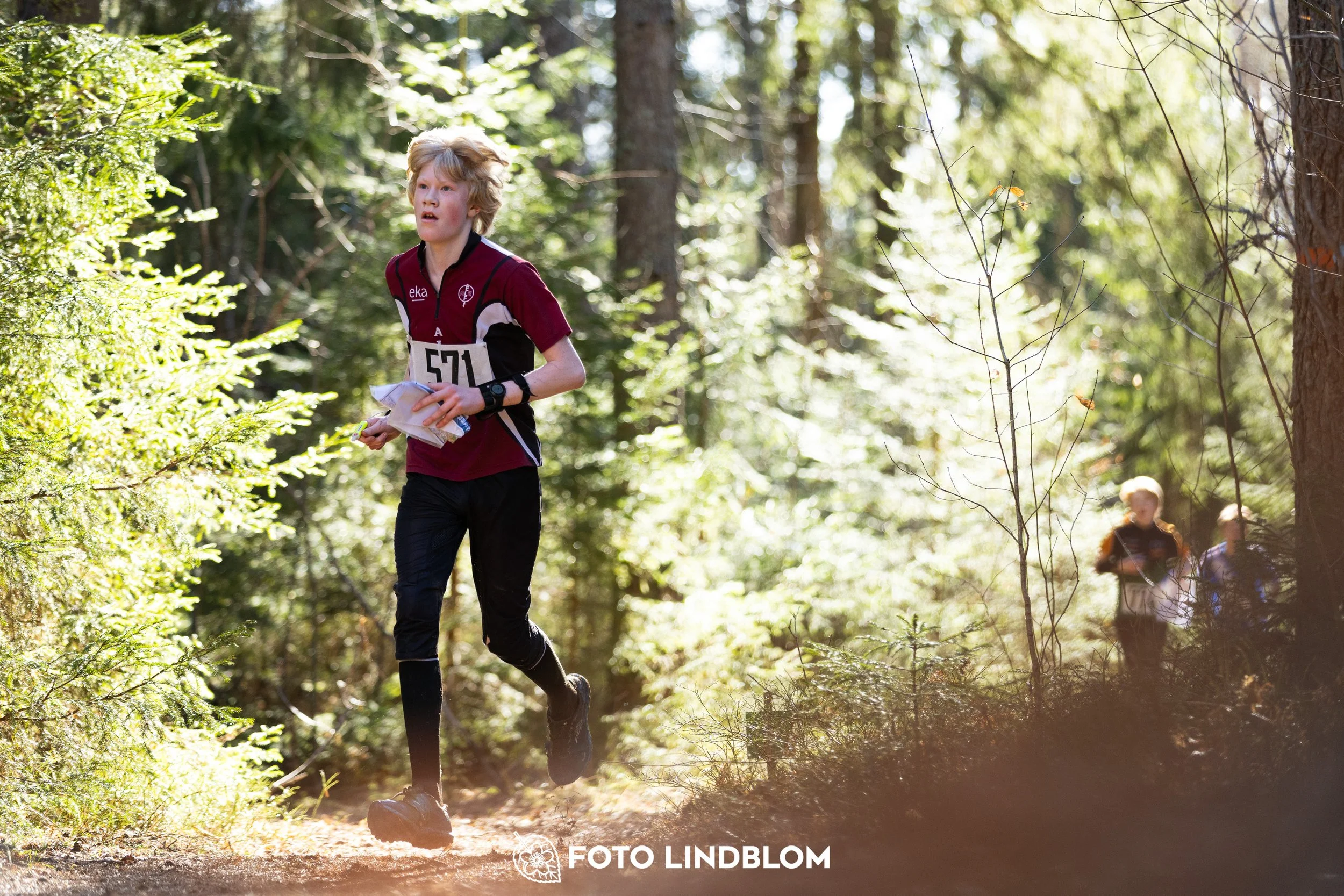 An image from Nyköpingsorienteringen 2026 featuring orienteers in a wooded landscape, shot by Foto Lindblom.
