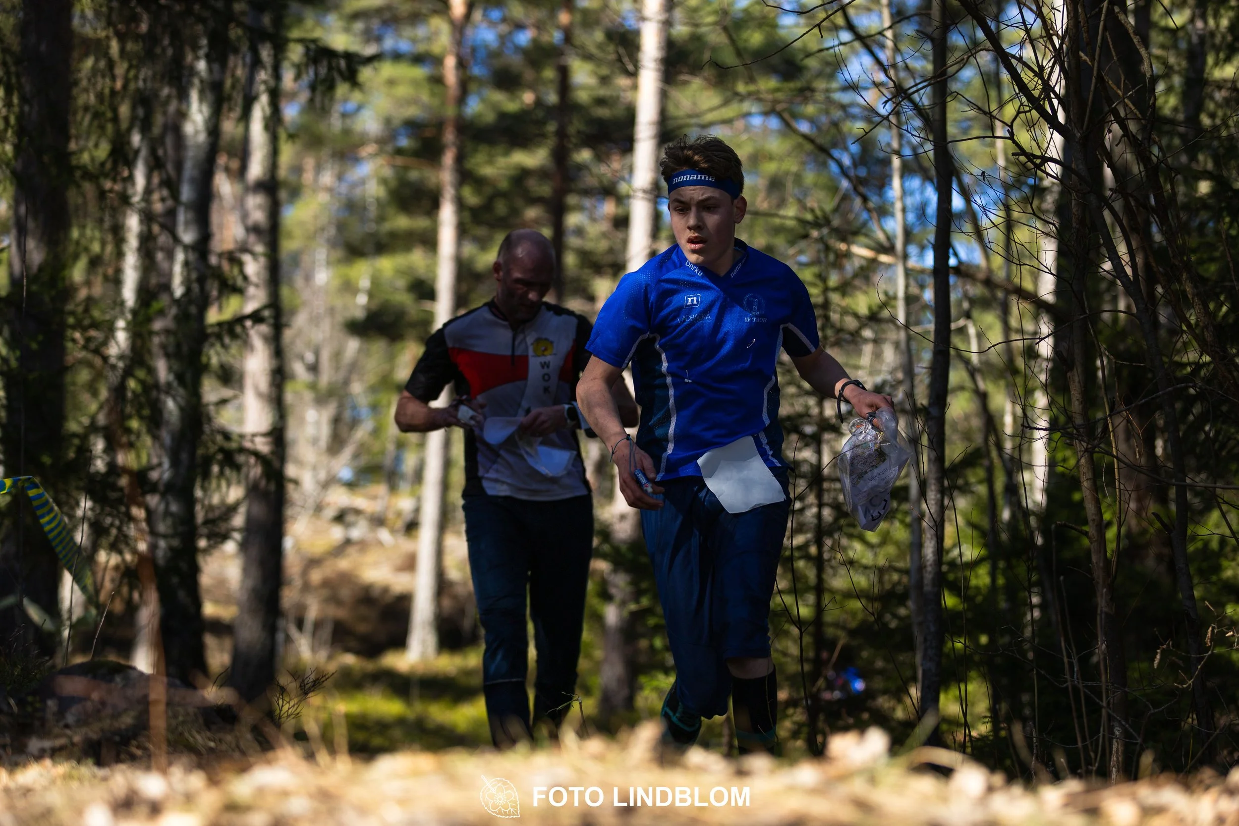 Image from Måsenstafetten 2026 showing orienteering relay teams competing in Swedish forest terrain, taken by Foto Lindblom.
