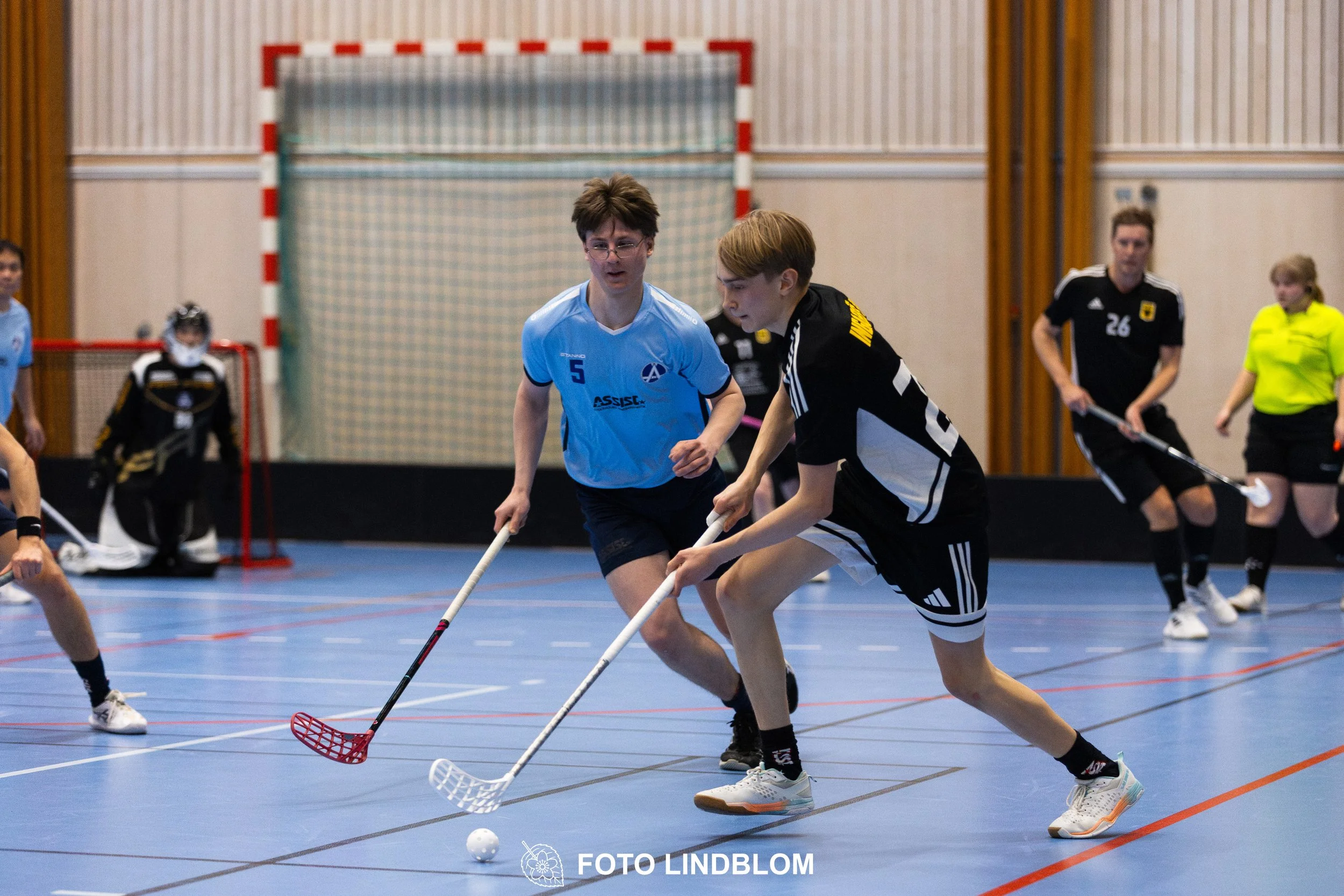 A picture of men playing floorball in Ingarö IF and Älvsjö AIK IBF team gear