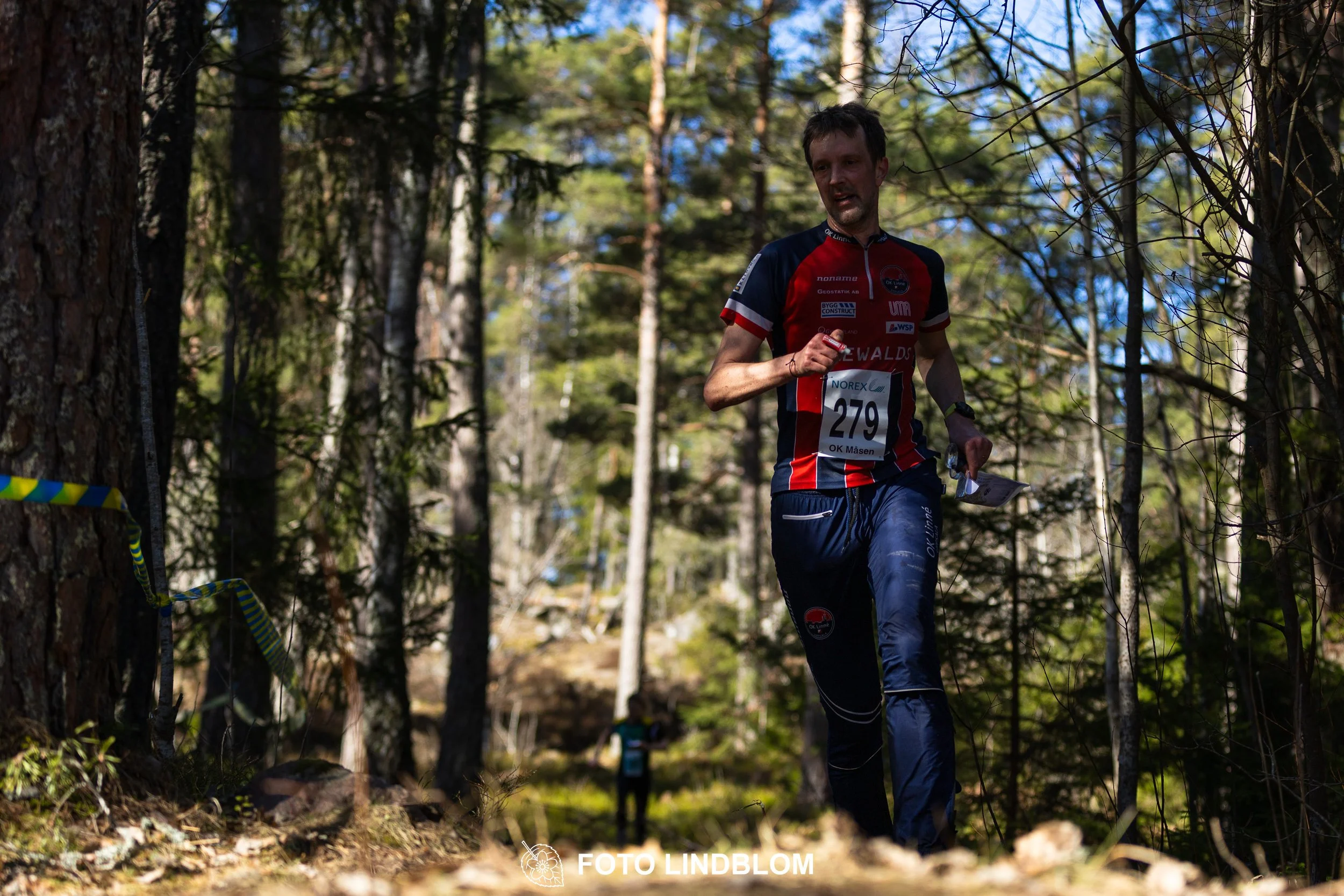 Image from Måsenstafetten 2026 showing orienteering relay teams competing in Swedish forest terrain, taken by Foto Lindblom.