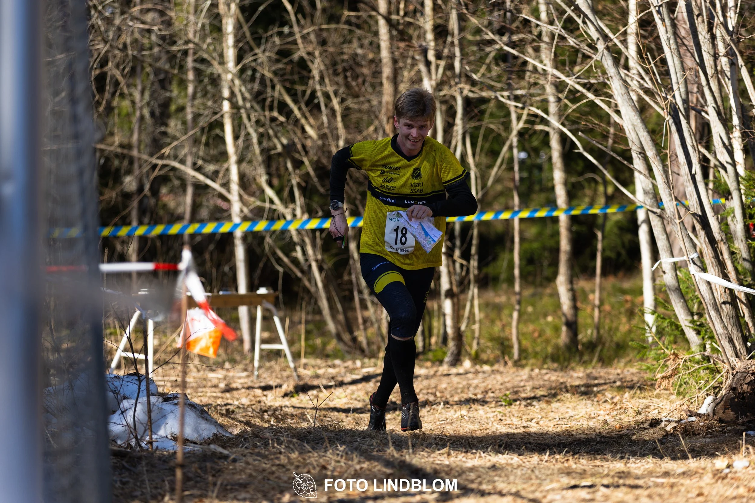 Orienteering relay race at Måsenstafetten 2026, featuring club teams navigating with map and compass, captured by Foto Lindblom.