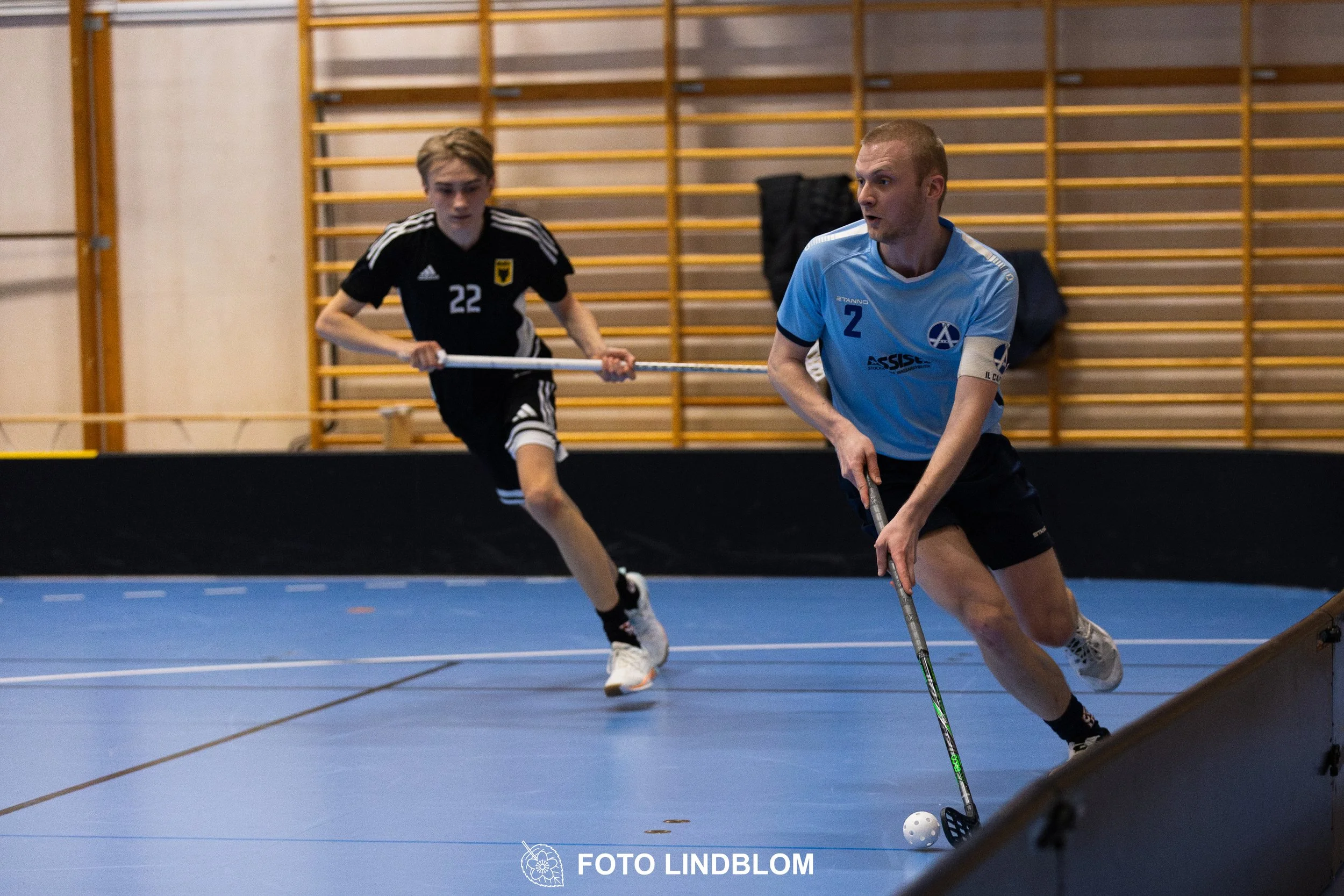 A picture of men playing floorball in Ingarö IF and Älvsjö AIK IBF team gear