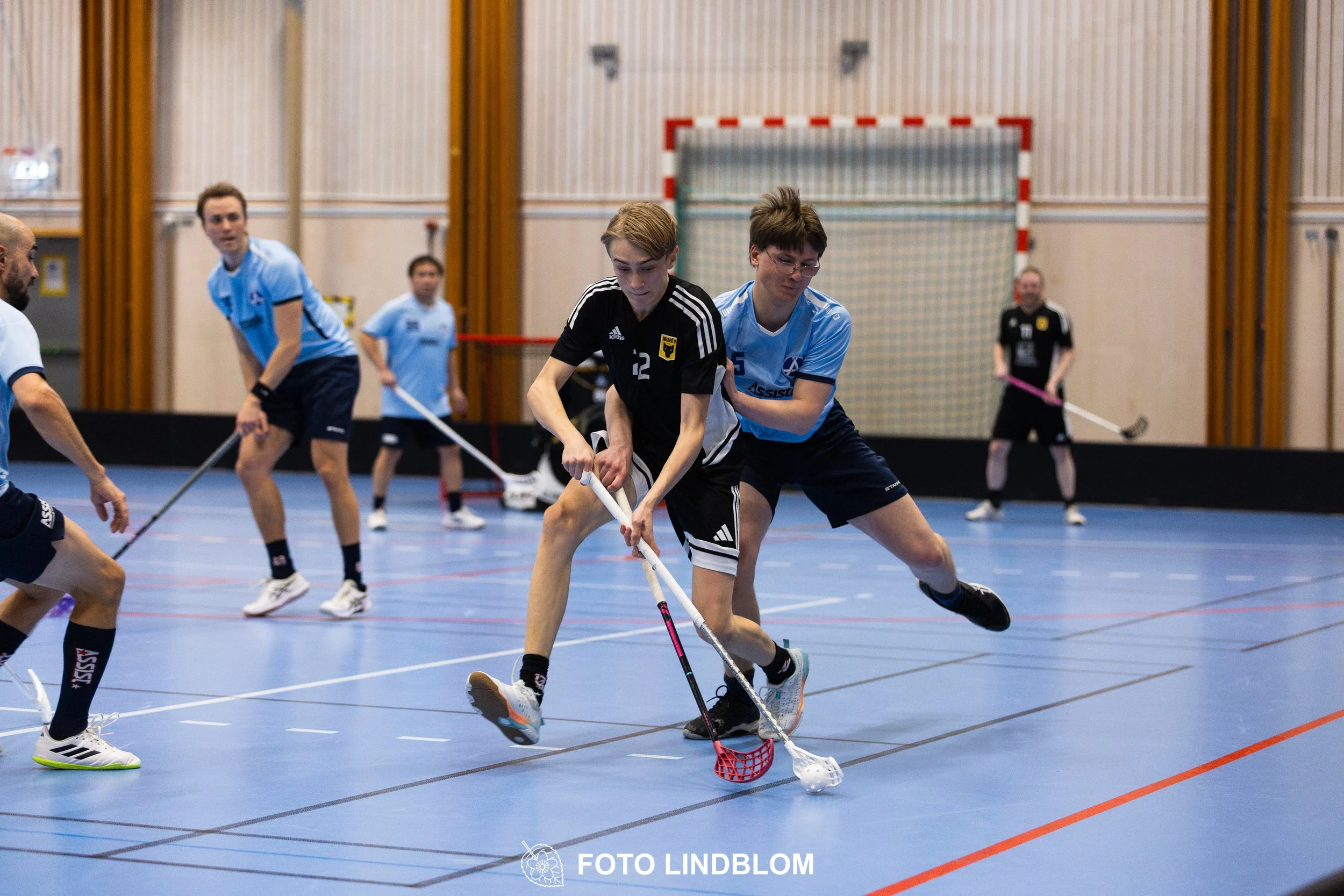 A picture of men playing floorball in Ingarö IF and Älvsjö AIK IBF team gear