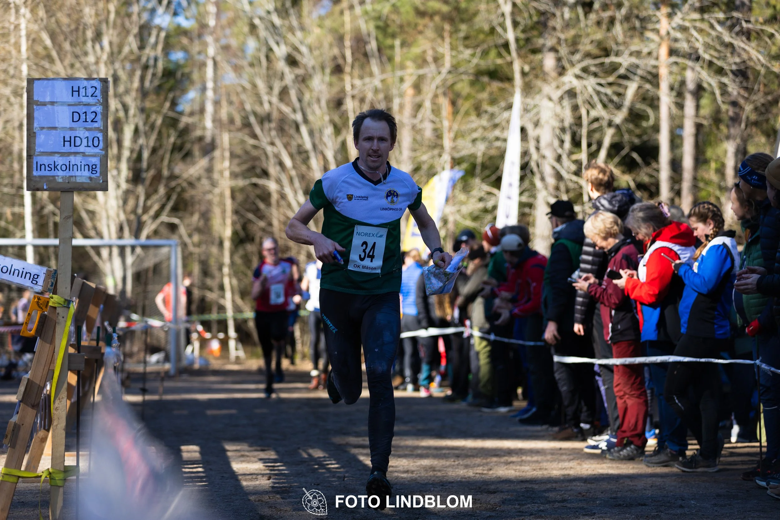 Orienteering relay race at Måsenstafetten 2026, featuring club teams navigating with map and compass, captured by Foto Lindblom.