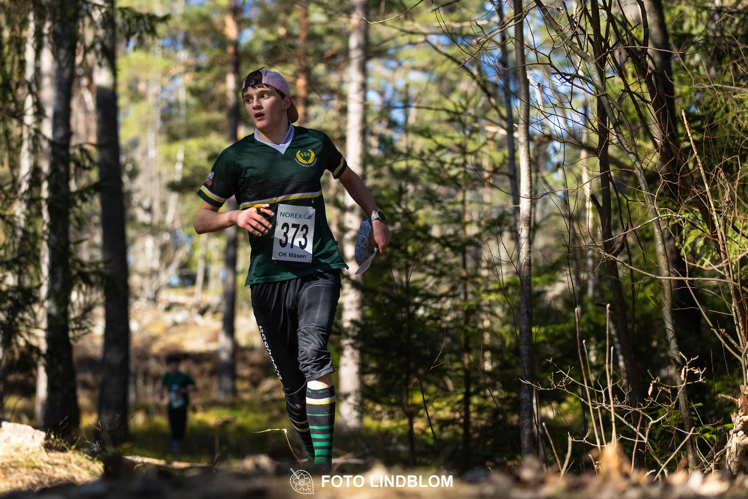 An image from the orienteering relay Måsenstafetten 2026, showing athletes in forest terrain, shot by Foto Lindblom.
