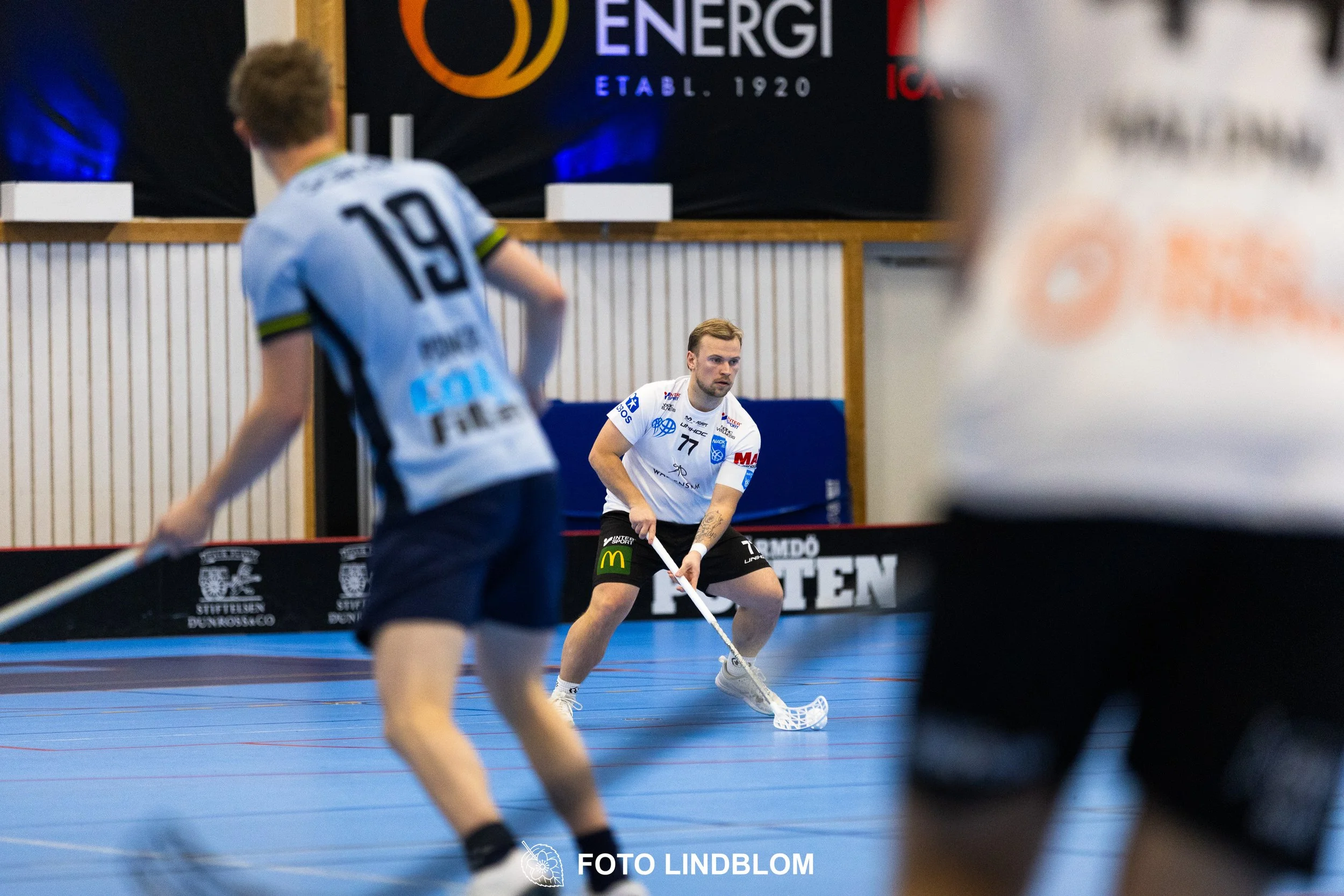 A picture of men playing floorball in Nacka IBK and FBC Sollentuna team gear