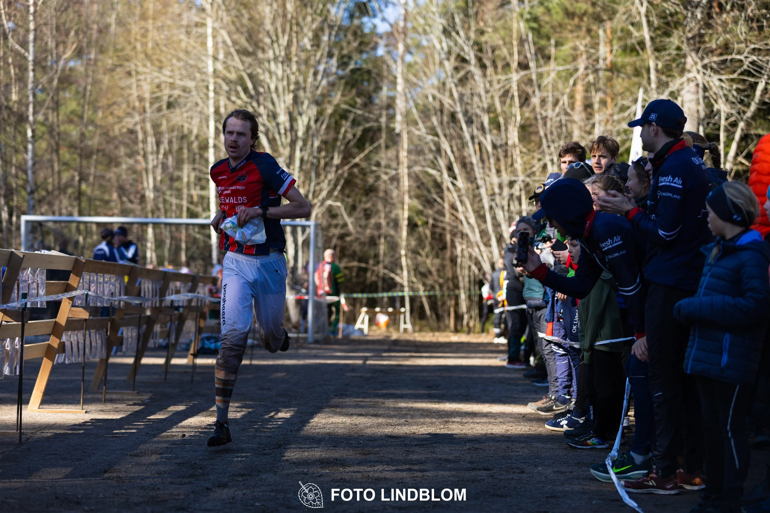 Image from Måsenstafetten 2026 showing orienteering relay teams competing in Swedish forest terrain, taken by Foto Lindblom.