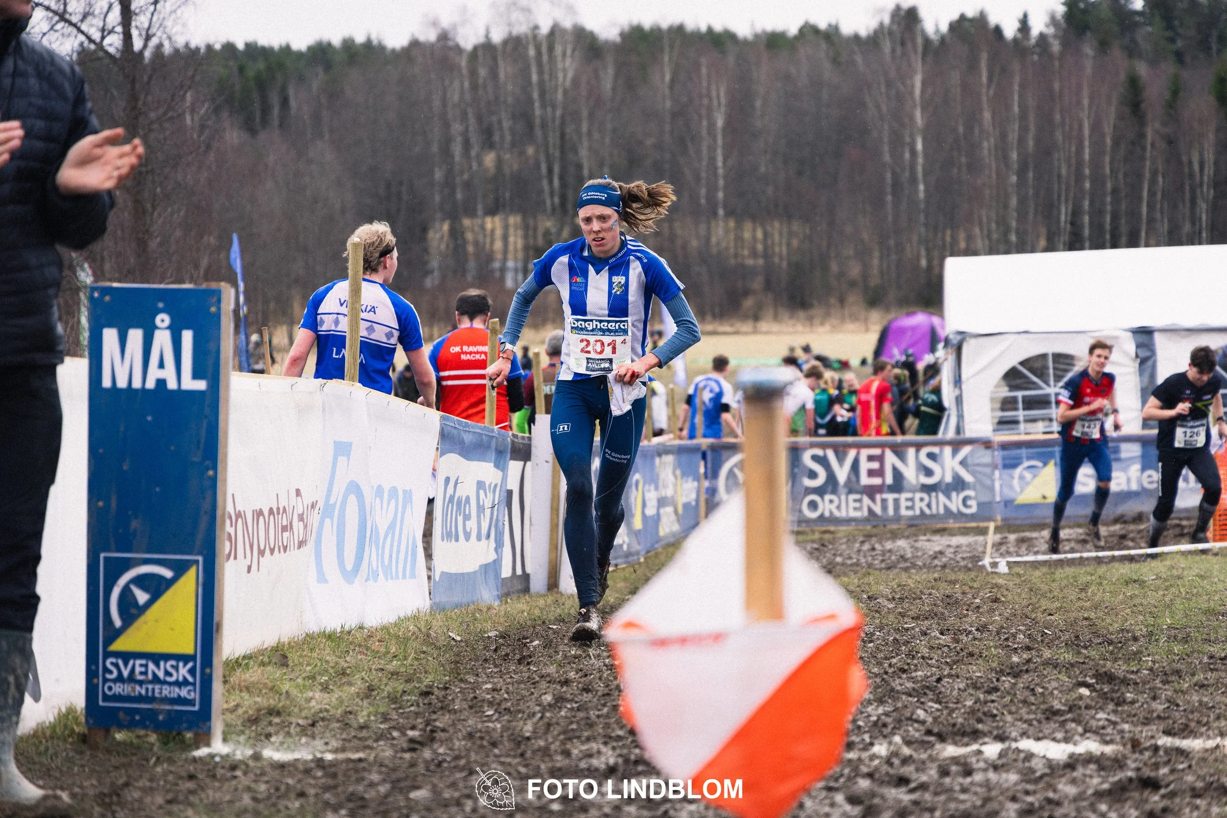 A photo from a Swedish relay orienteering event in Kolmården 2026, showing Sanna Fast, captured by Foto Lindblom.