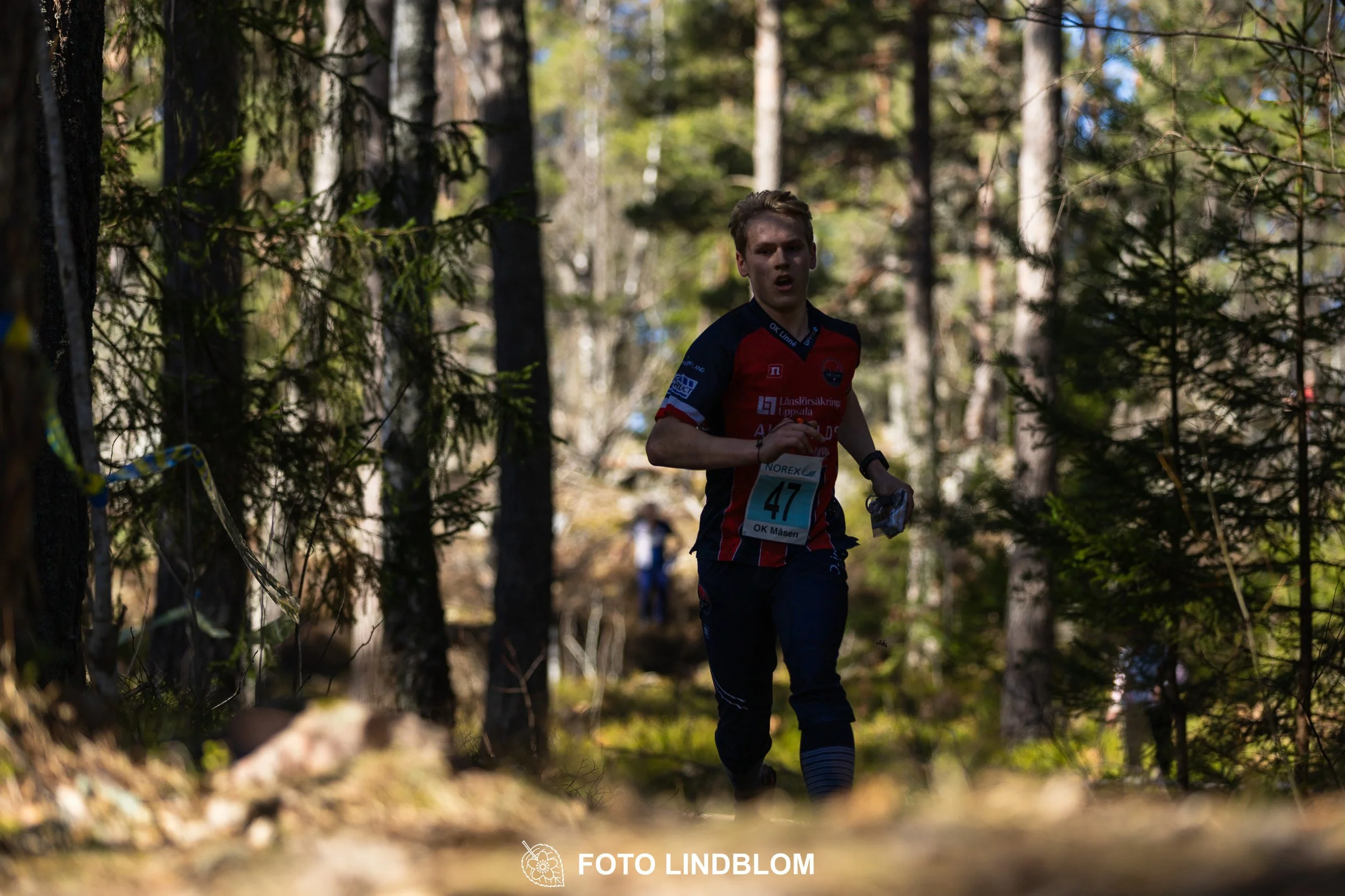 A relay-stage photo from Måsenstafetten 2026, featuring team-based orienteering competition, taken by Foto Lindblom.