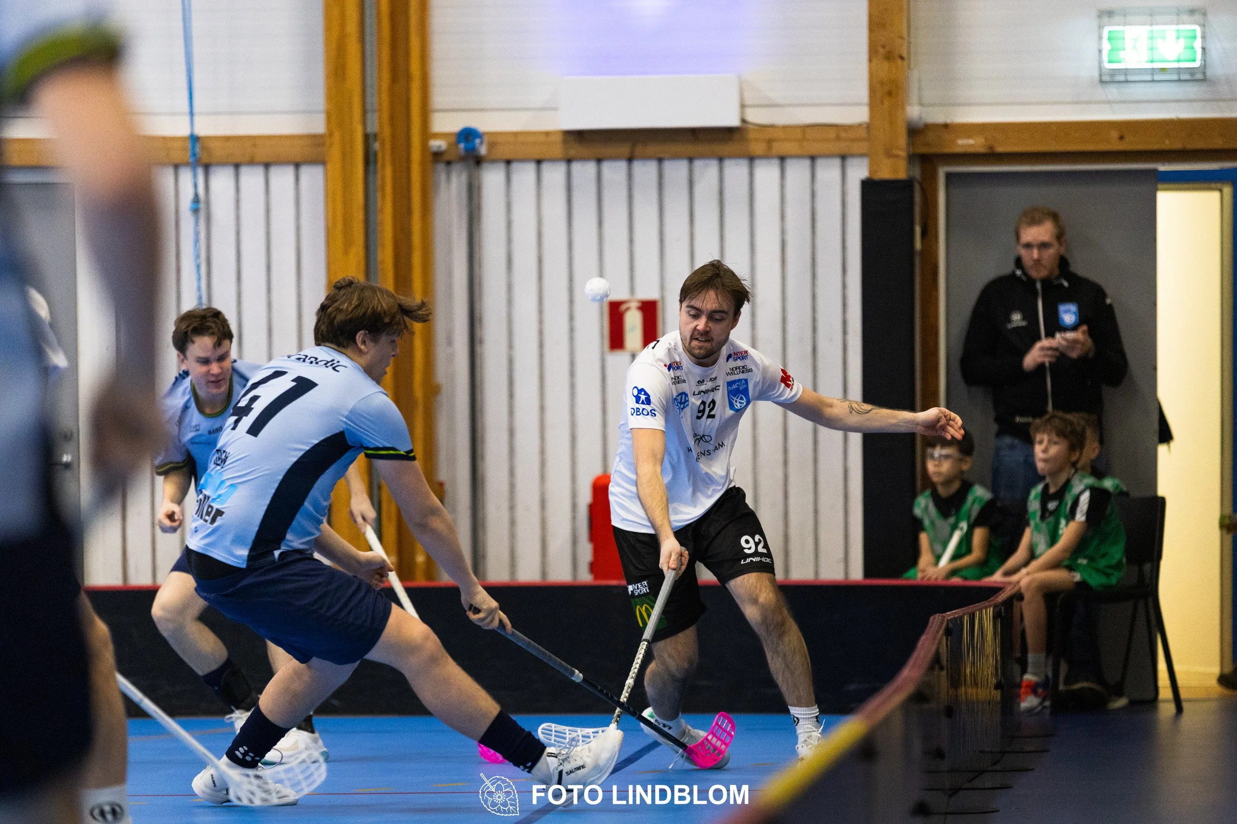 A picture of men playing floorball in Nacka IBK and FBC Sollentuna team gear