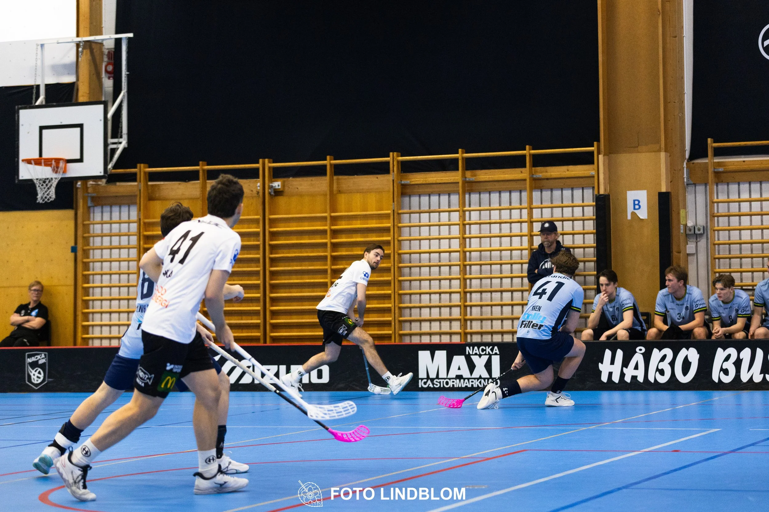 A picture of men playing floorball in Nacka IBK and FBC Sollentuna team gear