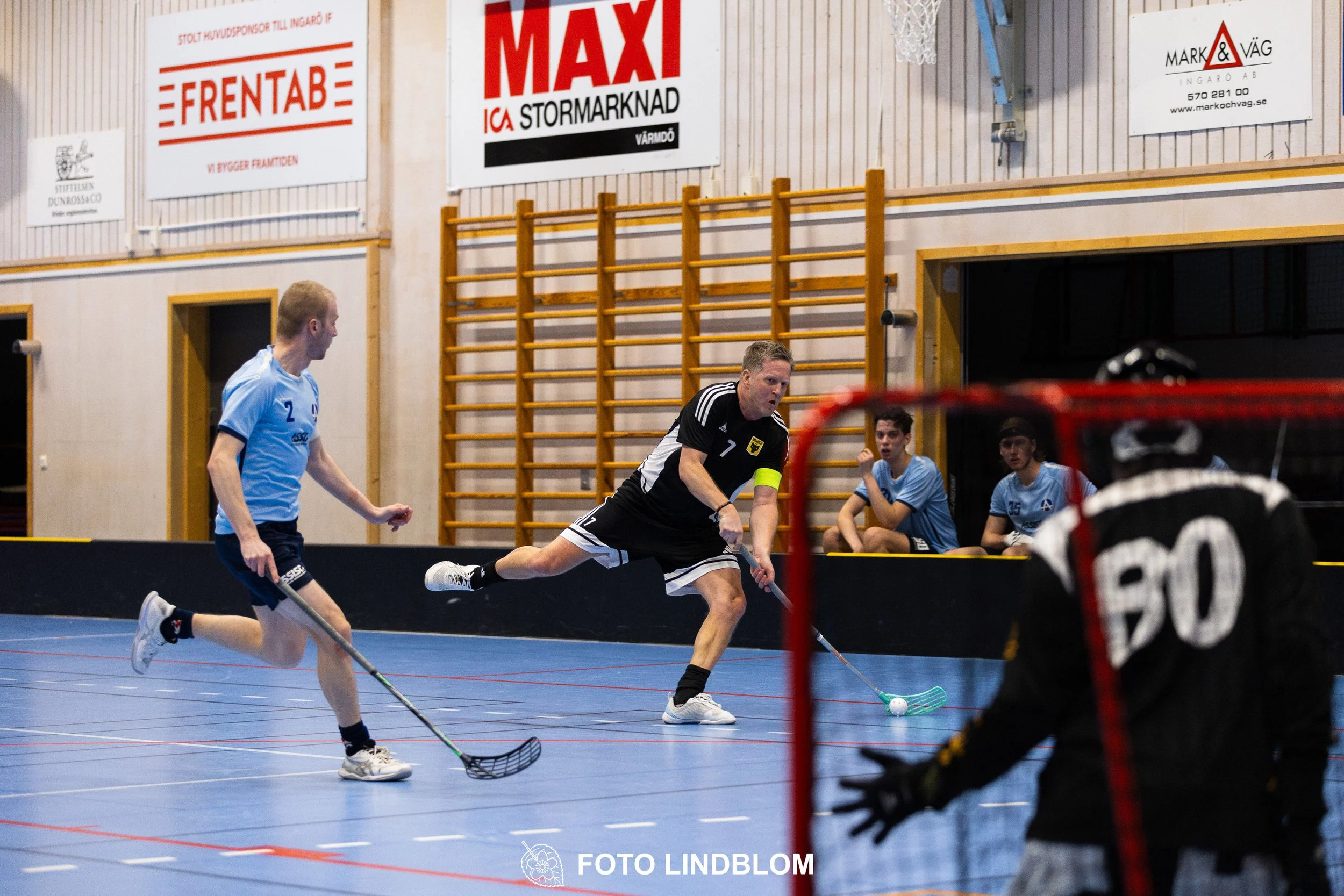 A picture of men playing floorball in Ingarö IF and Älvsjö AIK IBF team gear
