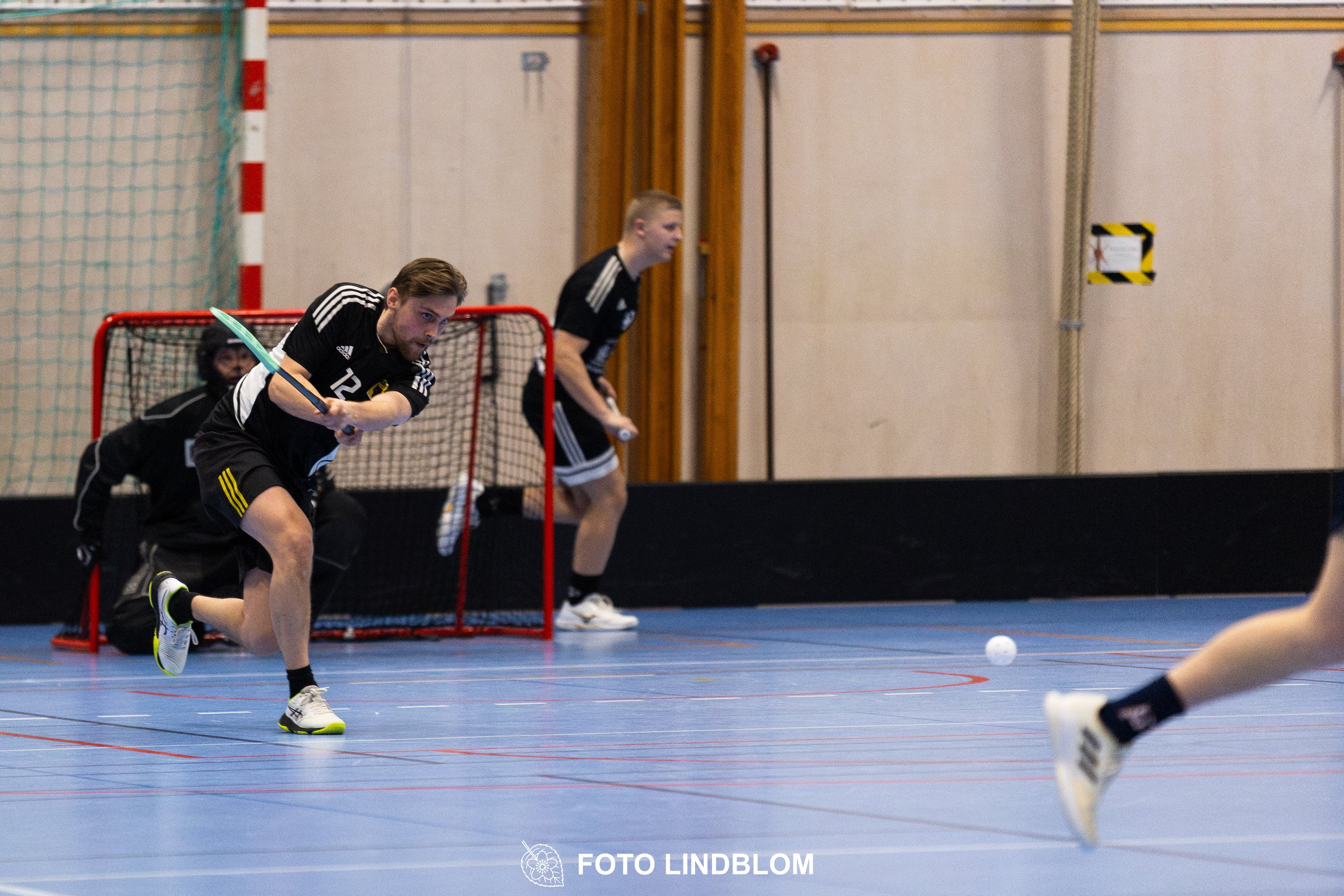 A picture of men playing floorball in Ingarö IF and Älvsjö AIK IBF team gear