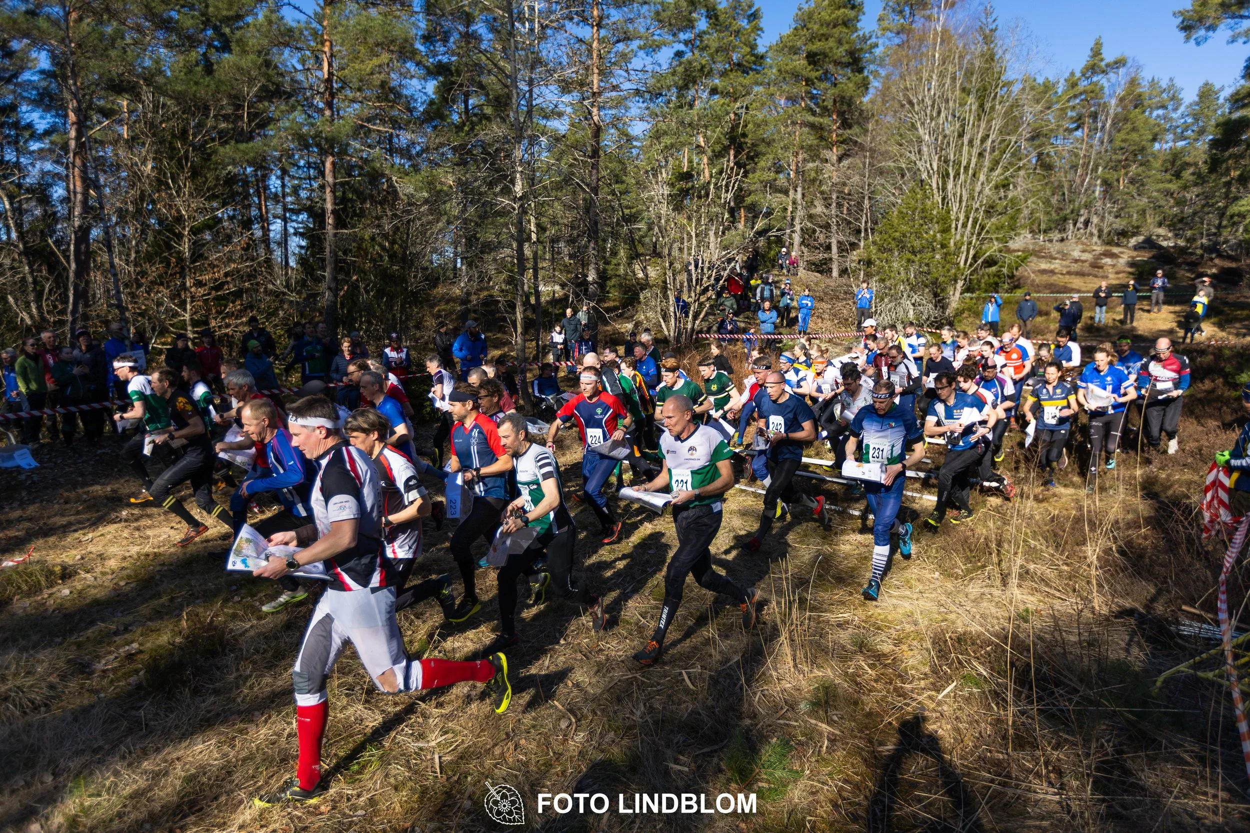 Orienteering relay race at Måsenstafetten 2026, featuring club teams navigating with map and compass, captured by Foto Lindblom.