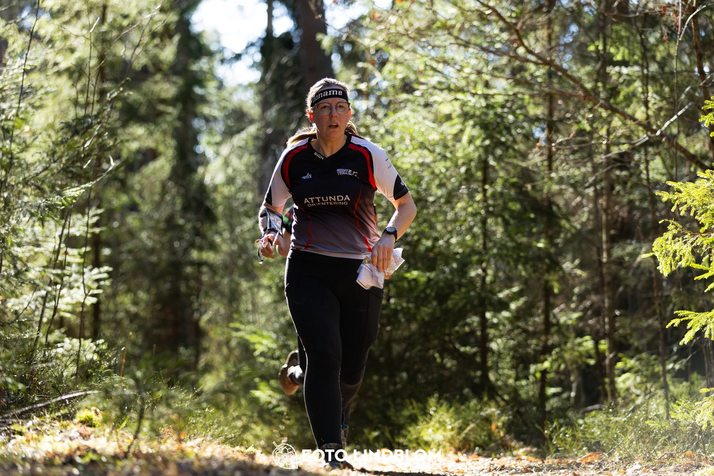 A photo from the 2026 Nyköpingsorienteringen orienteering event in a Swedish forest, captured by Foto Lindblom.