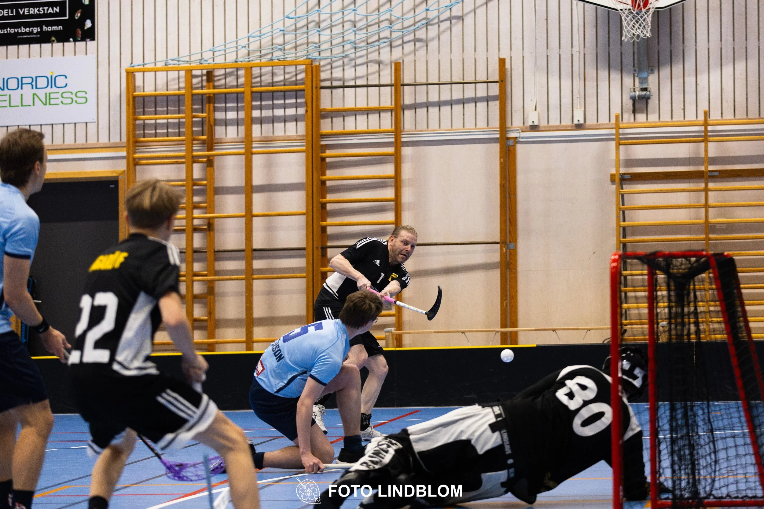 A picture of men playing floorball in Ingarö IF and Älvsjö AIK IBF team gear