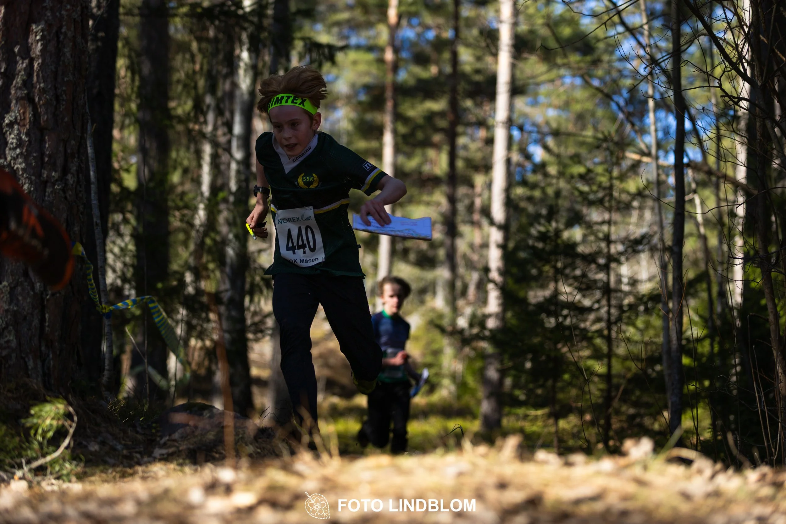 Orienteering relay race at Måsenstafetten 2026, featuring club teams navigating with map and compass, captured by Foto Lindblom.