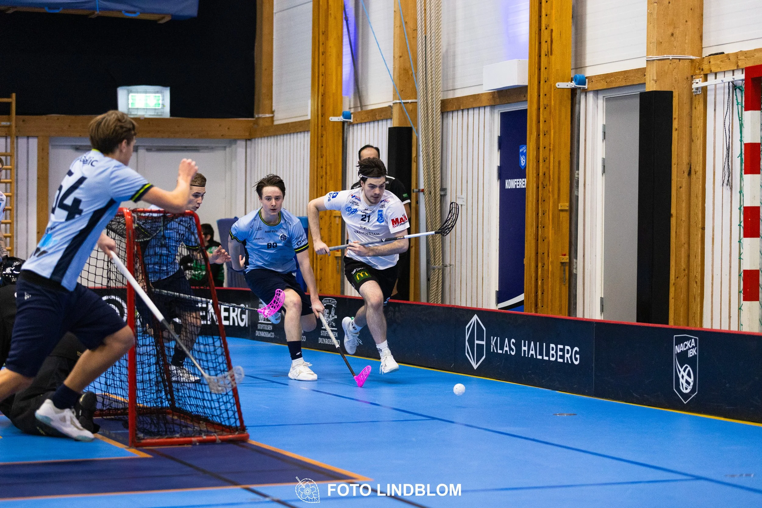 A picture of men playing floorball in Nacka IBK and FBC Sollentuna team gear