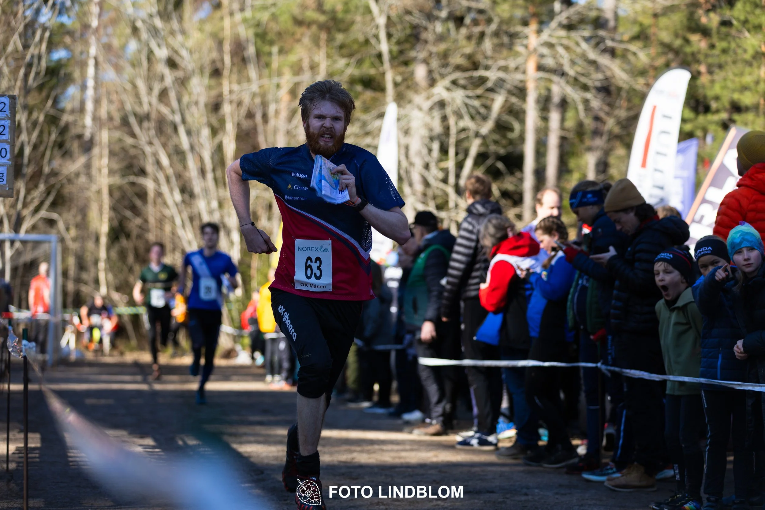An image from the orienteering relay Måsenstafetten 2026, showing athletes in forest terrain, shot by Foto Lindblom.