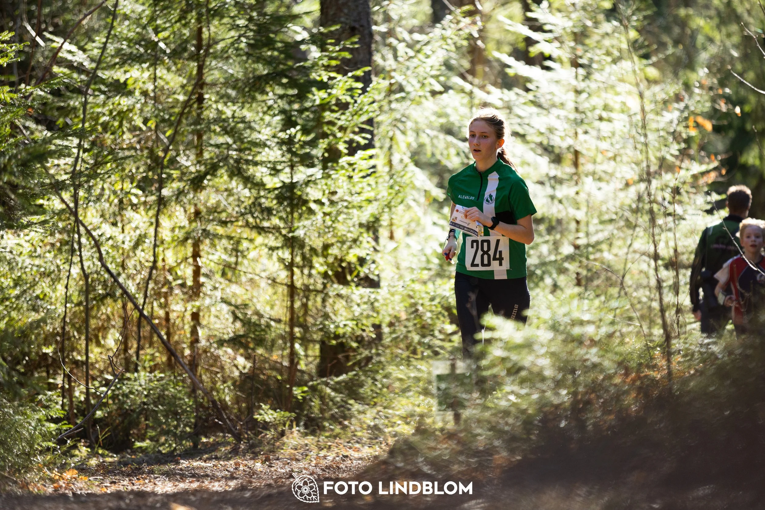 Image from Nyköpingsorienteringen 2026 showing competitors navigating forest terrain, taken by Foto Lindblom.