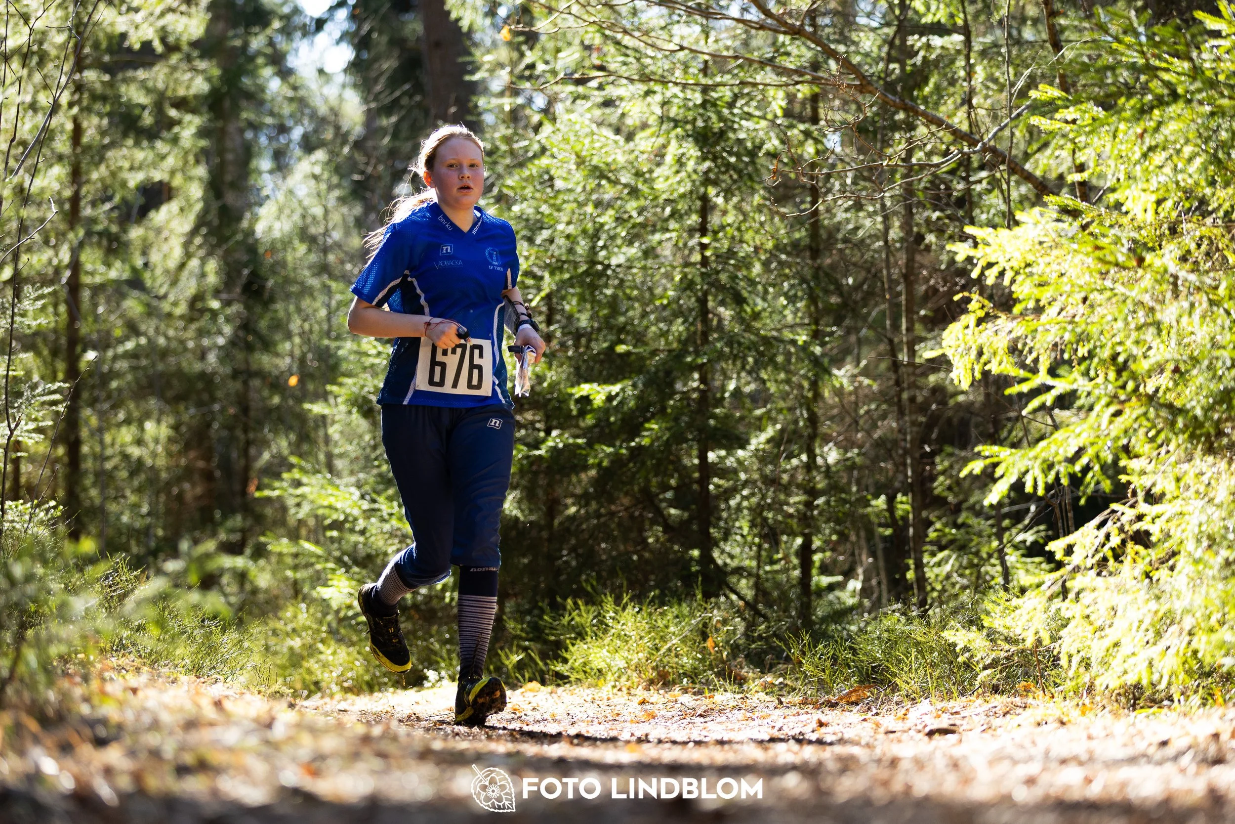 A photo from the 2026 Nyköpingsorienteringen orienteering event in a Swedish forest, captured by Foto Lindblom.