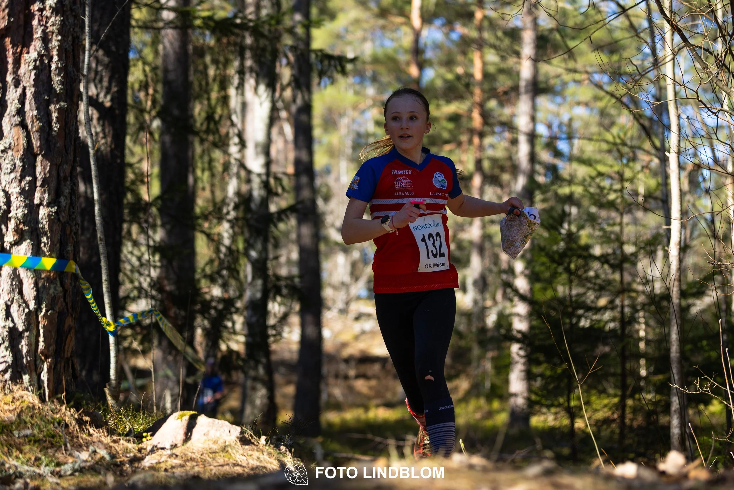 A relay-stage photo from Måsenstafetten 2026, featuring team-based orienteering competition, taken by Foto Lindblom.