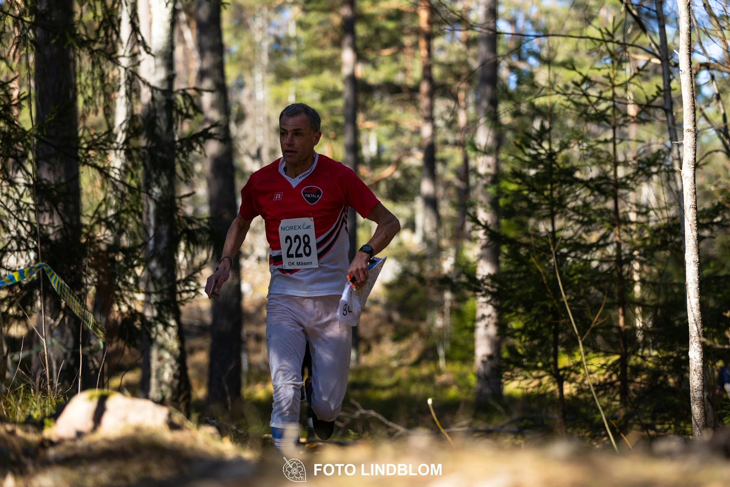 An image from the orienteering relay Måsenstafetten 2026, showing athletes in forest terrain, shot by Foto Lindblom.
