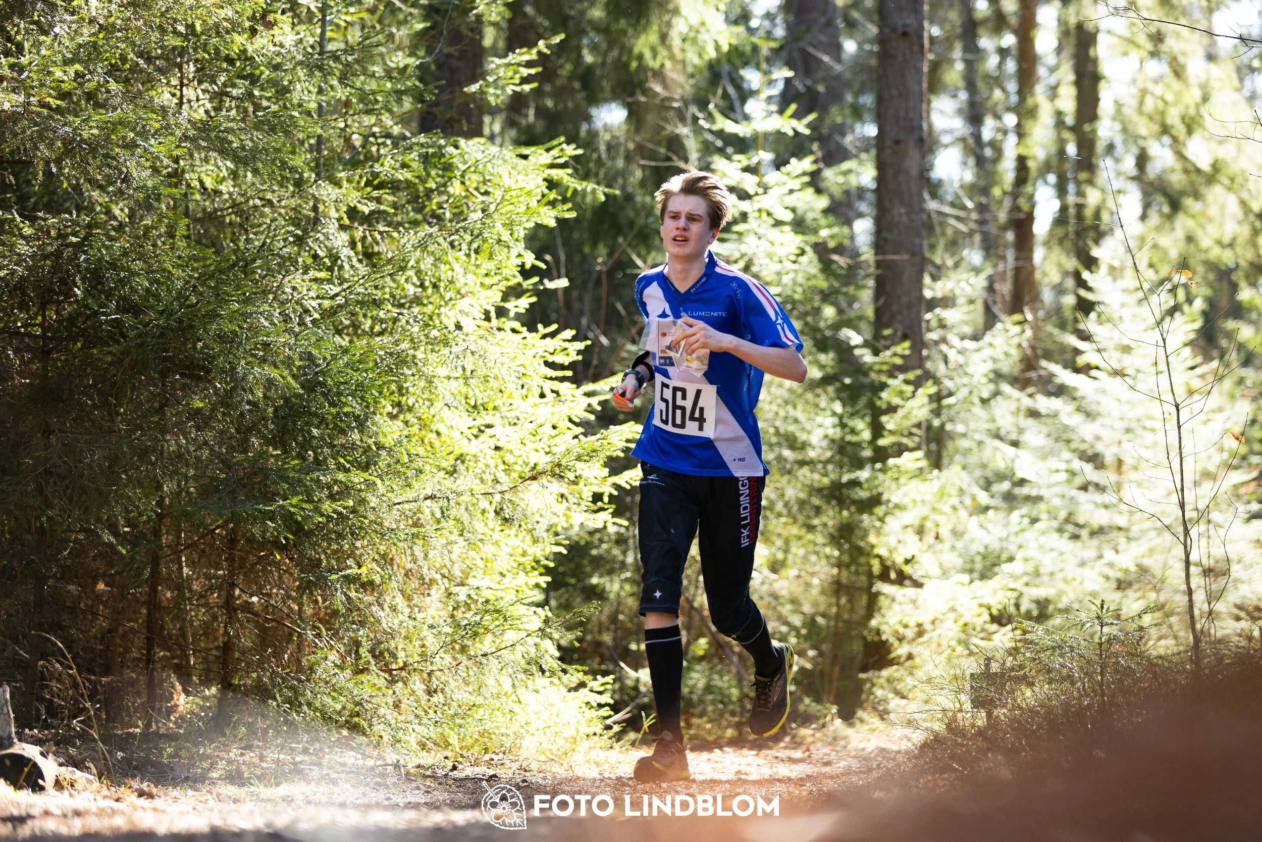 A photo from the 2026 Nyköpingsorienteringen orienteering event in a Swedish forest, captured by Foto Lindblom.