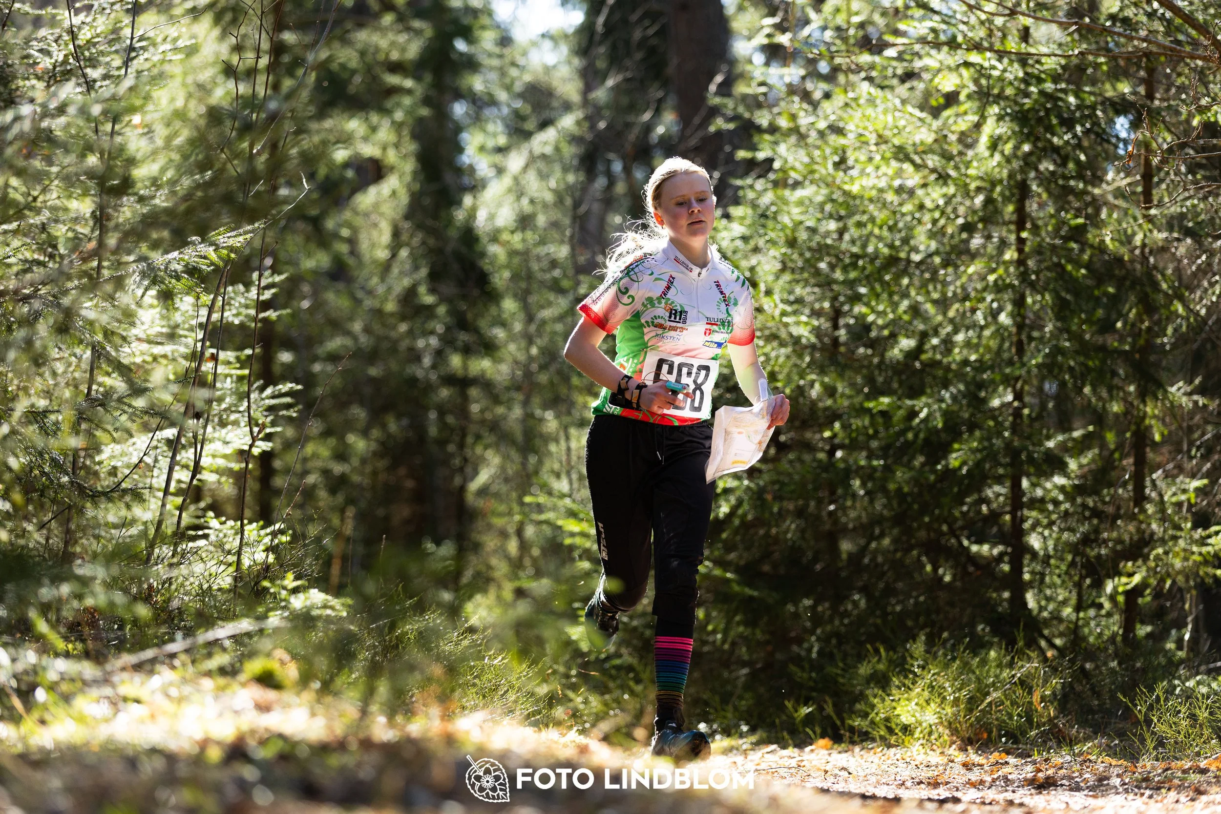A photo from the 2026 Nyköpingsorienteringen orienteering event in a Swedish forest, captured by Foto Lindblom.