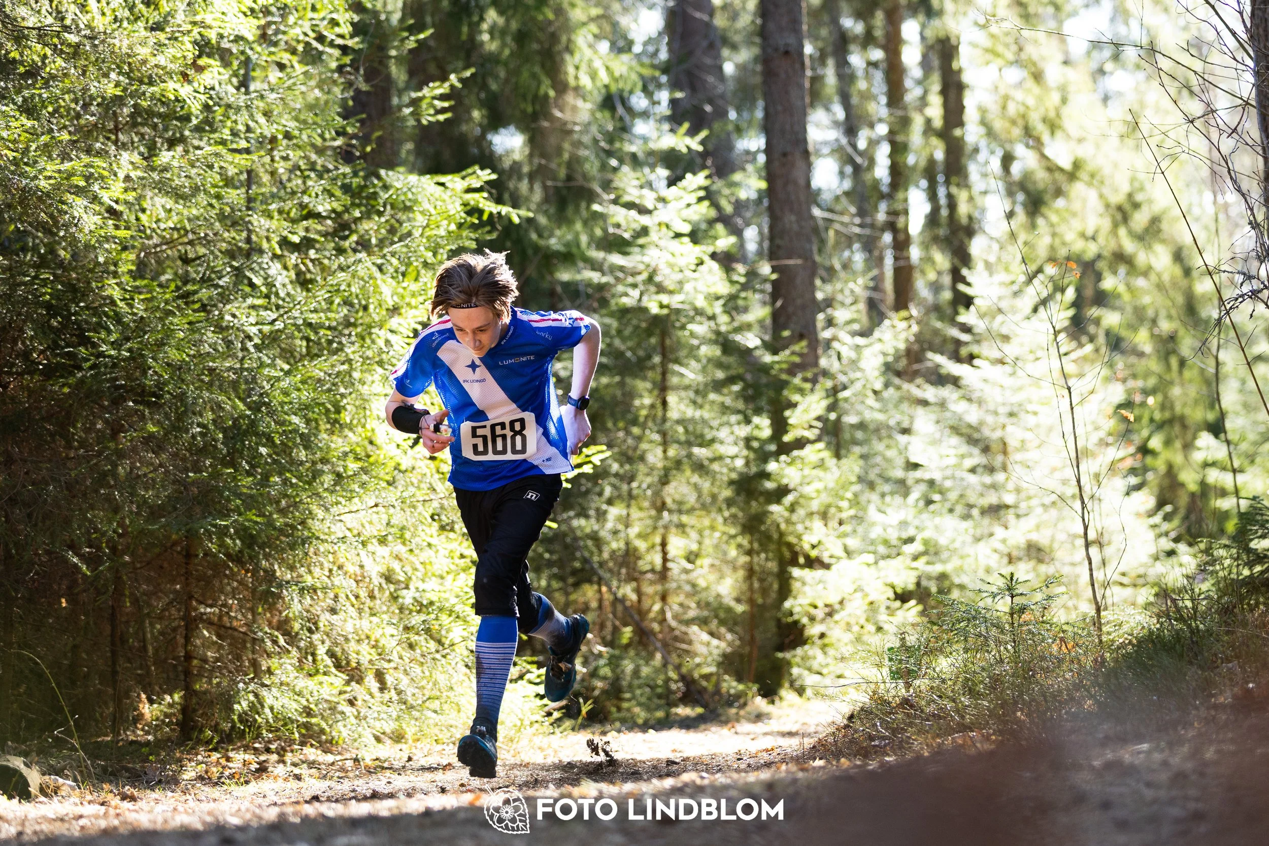 An image from Nyköpingsorienteringen 2026 featuring orienteers in a wooded landscape, shot by Foto Lindblom.