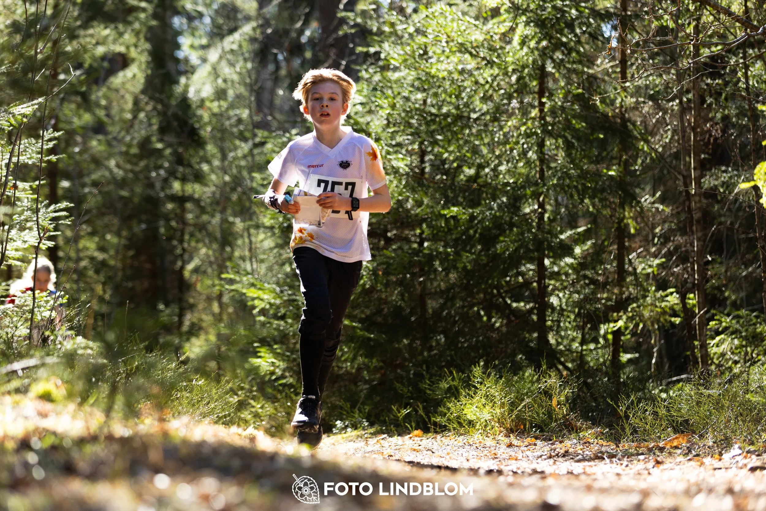 Image from Nyköpingsorienteringen 2026 showing competitors navigating forest terrain, taken by Foto Lindblom.