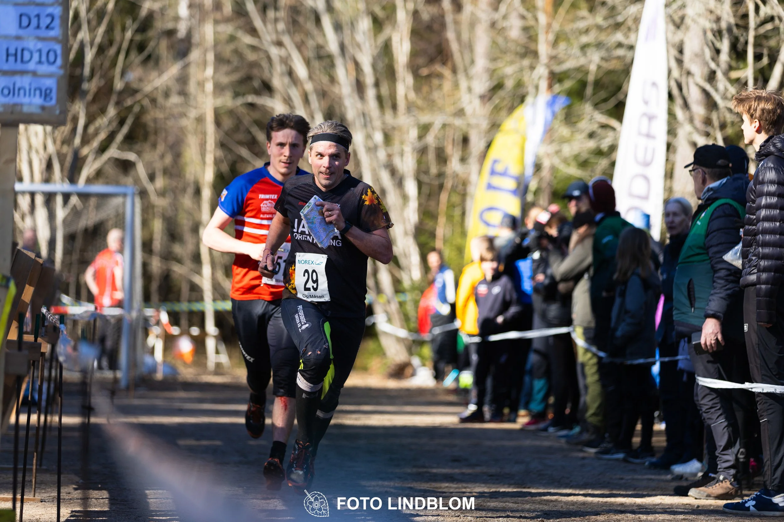 A relay-stage photo from Måsenstafetten 2026, featuring team-based orienteering competition, taken by Foto Lindblom.
