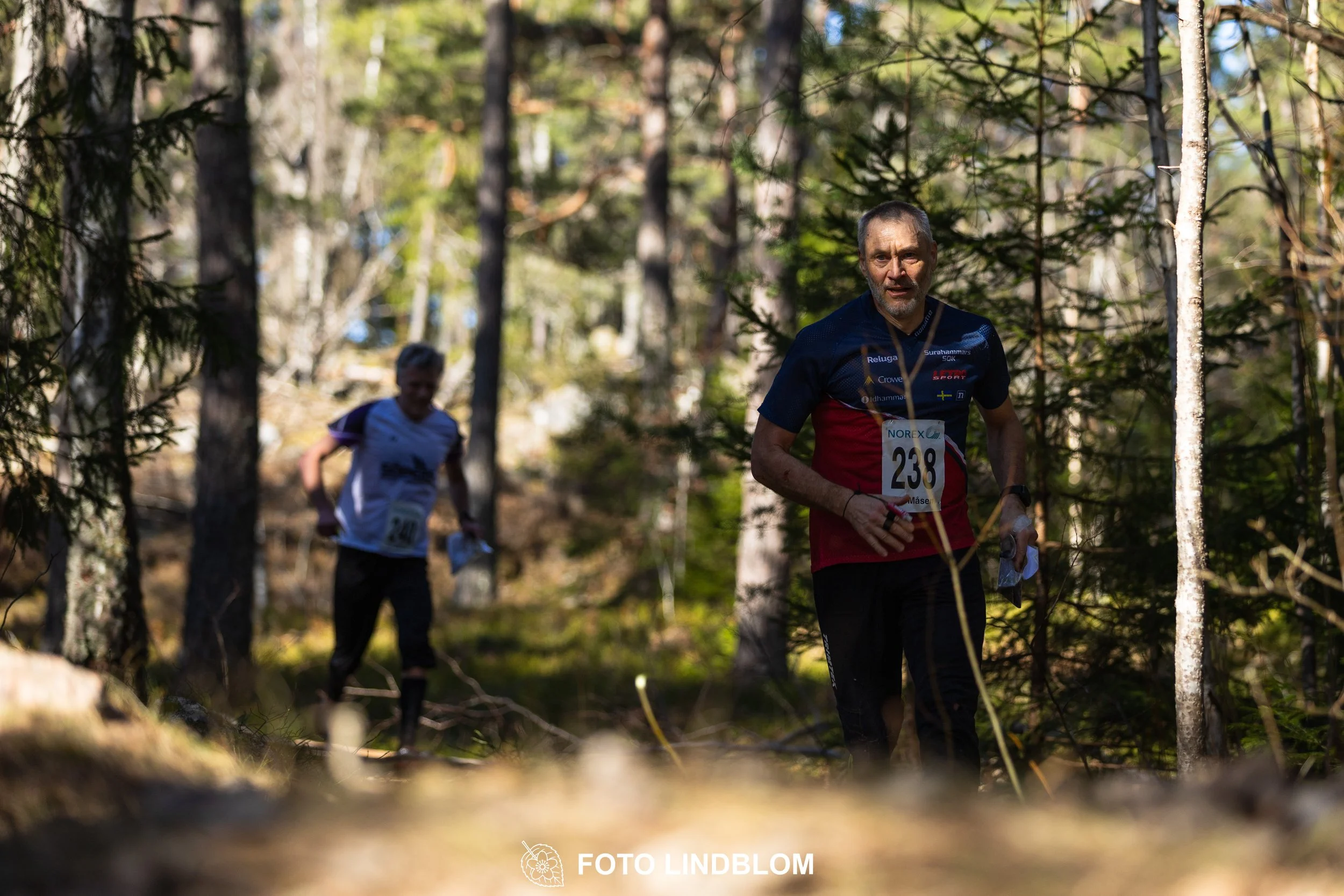 A relay-stage photo from Måsenstafetten 2026, featuring team-based orienteering competition, taken by Foto Lindblom.
