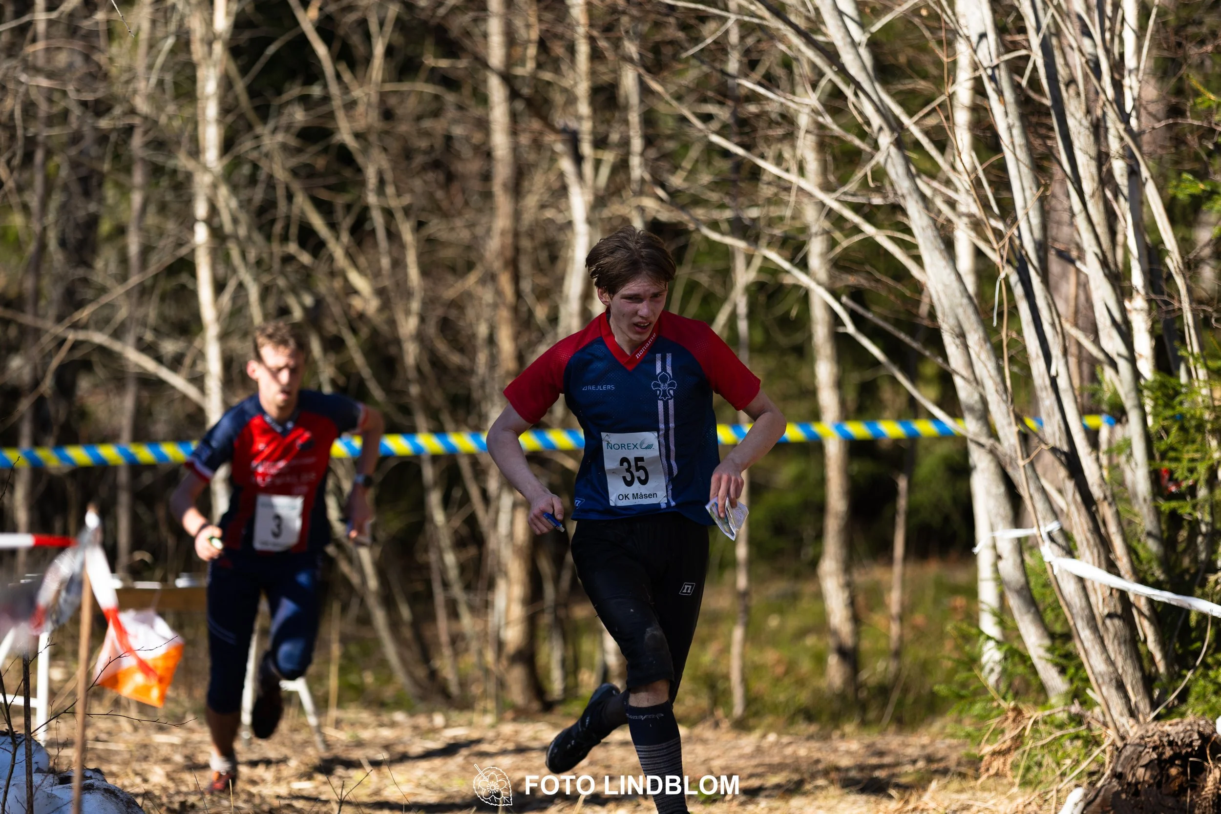 An image from the orienteering relay Måsenstafetten 2026, showing athletes in forest terrain, shot by Foto Lindblom.