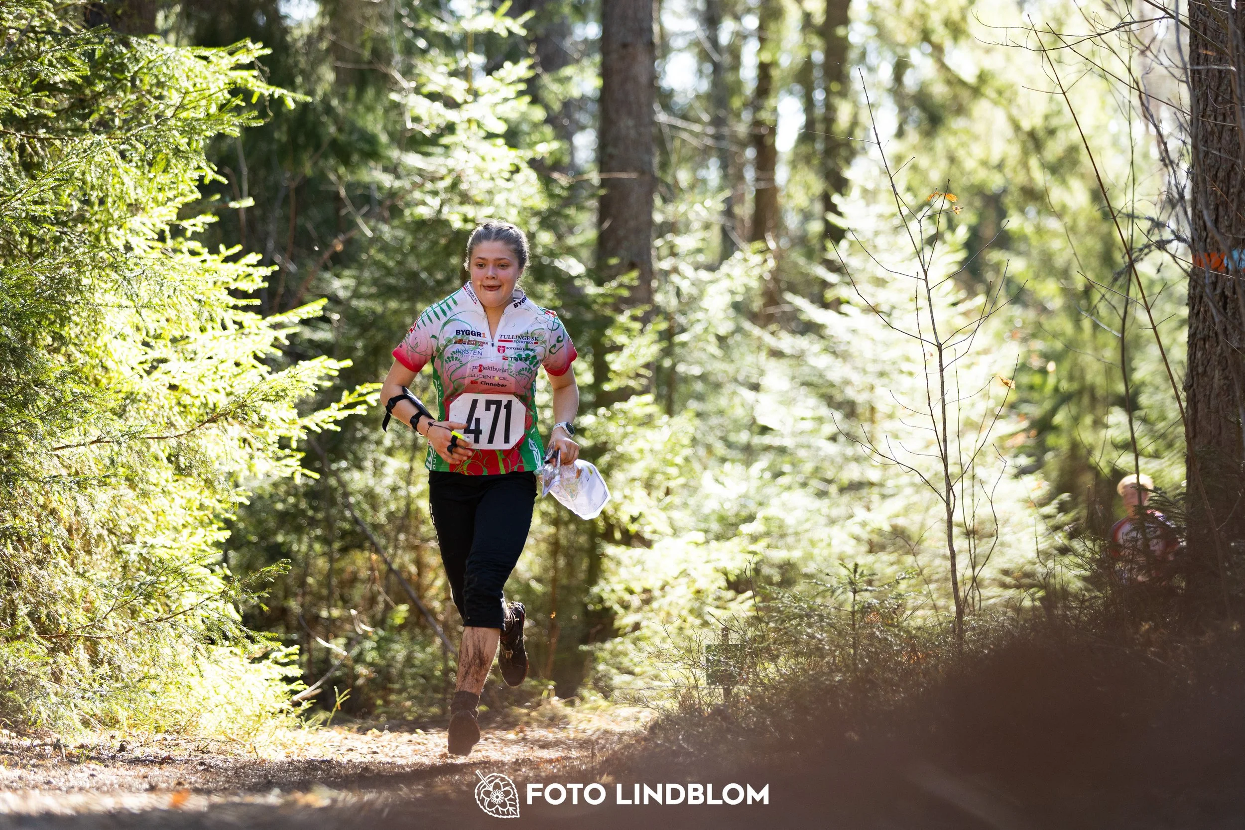 Image from Nyköpingsorienteringen 2026 showing competitors navigating forest terrain, taken by Foto Lindblom.