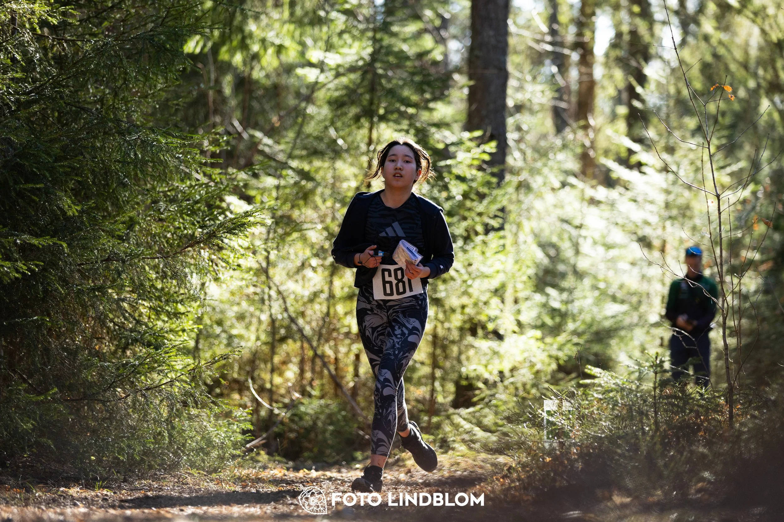 A photo from the 2026 Nyköpingsorienteringen orienteering event in a Swedish forest, captured by Foto Lindblom.