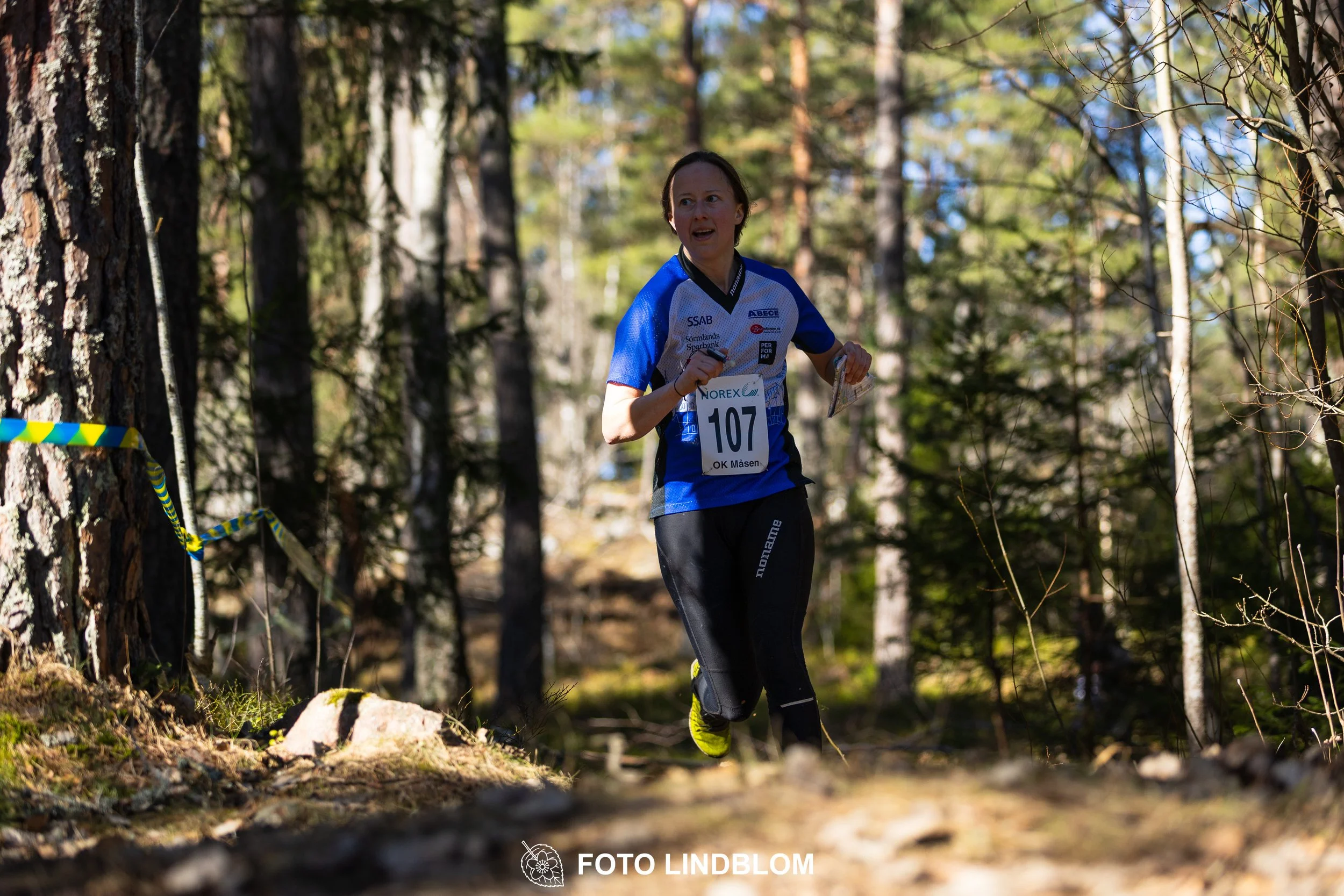 Orienteering relay race at Måsenstafetten 2026, featuring club teams navigating with map and compass, captured by Foto Lindblom.