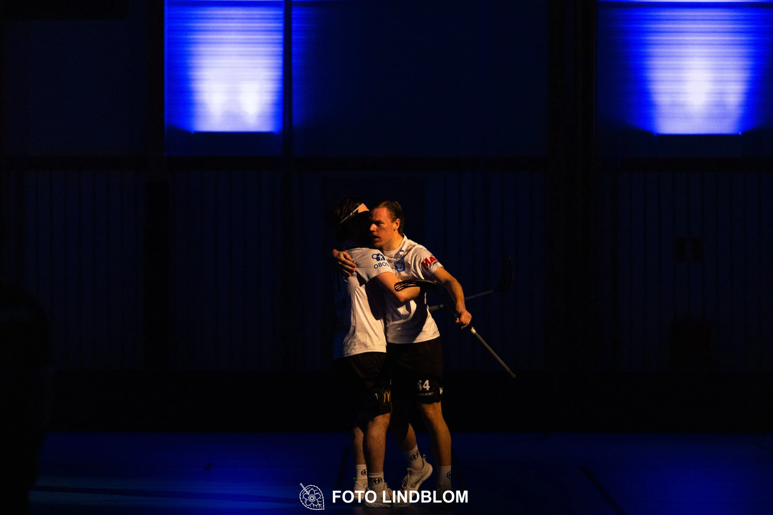 A picture of men playing floorball in Nacka IBK and FBC Sollentuna team gear