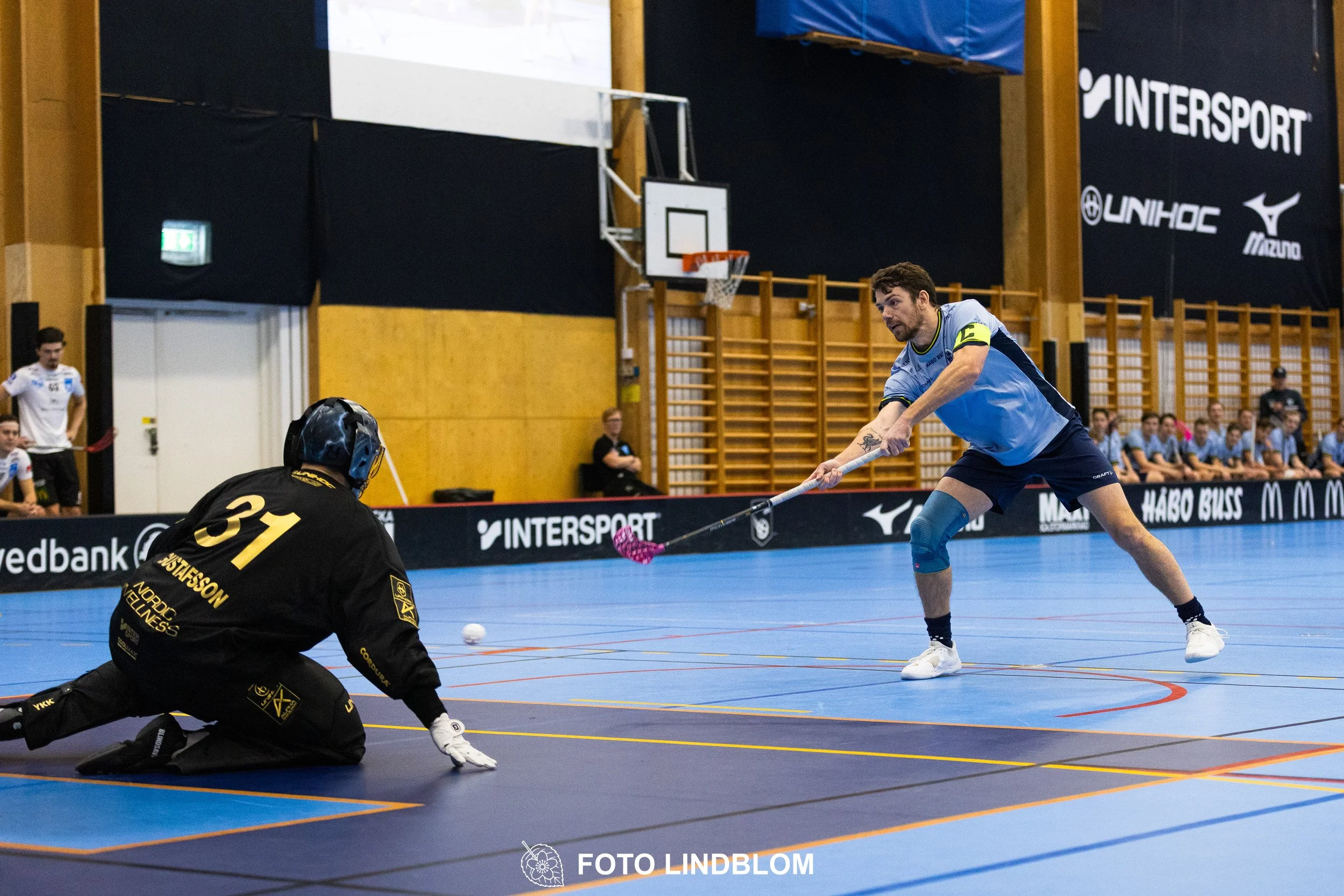 A picture of men playing floorball in Nacka IBK and FBC Sollentuna team gear
