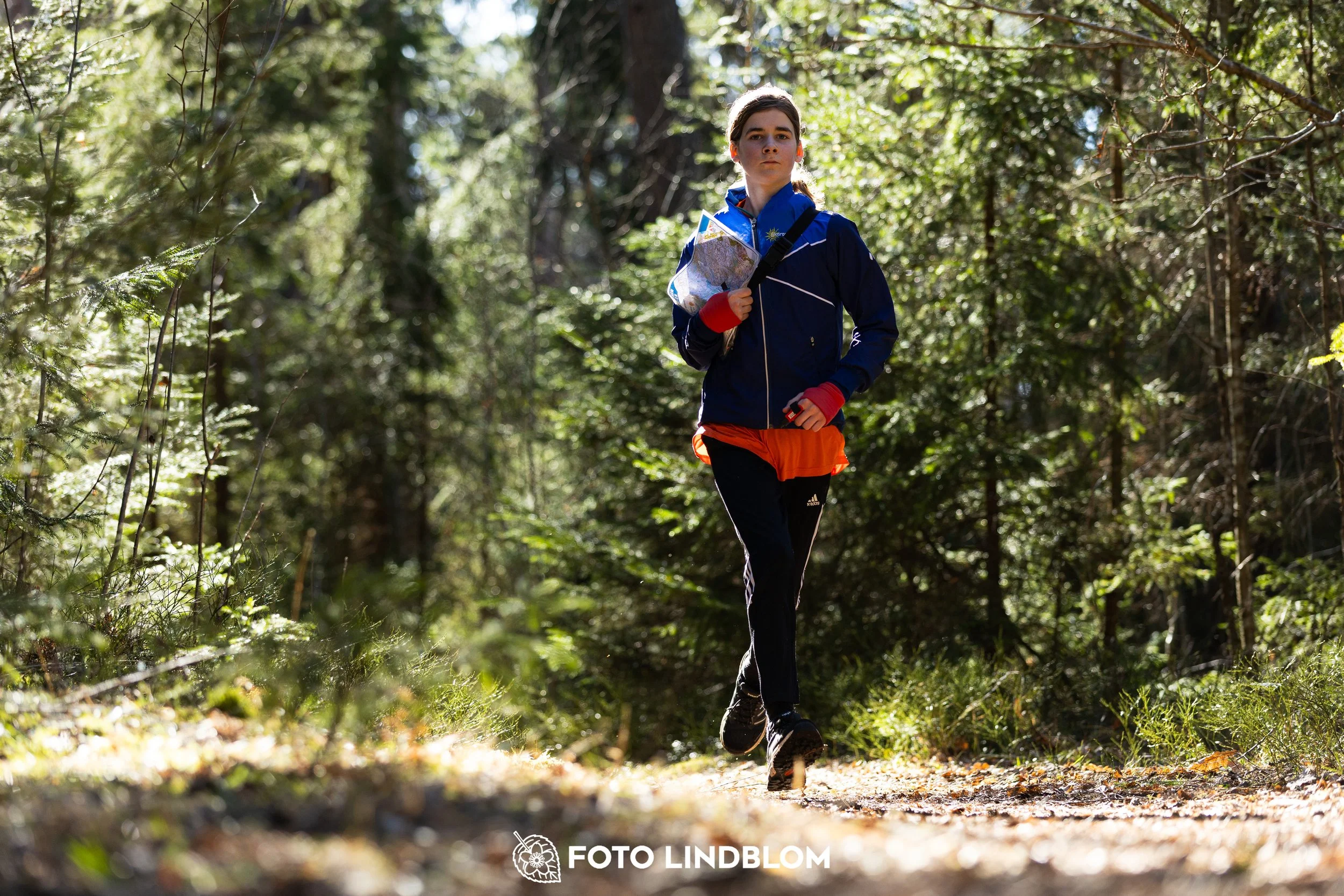 Image from Nyköpingsorienteringen 2026 showing competitors navigating forest terrain, taken by Foto Lindblom.