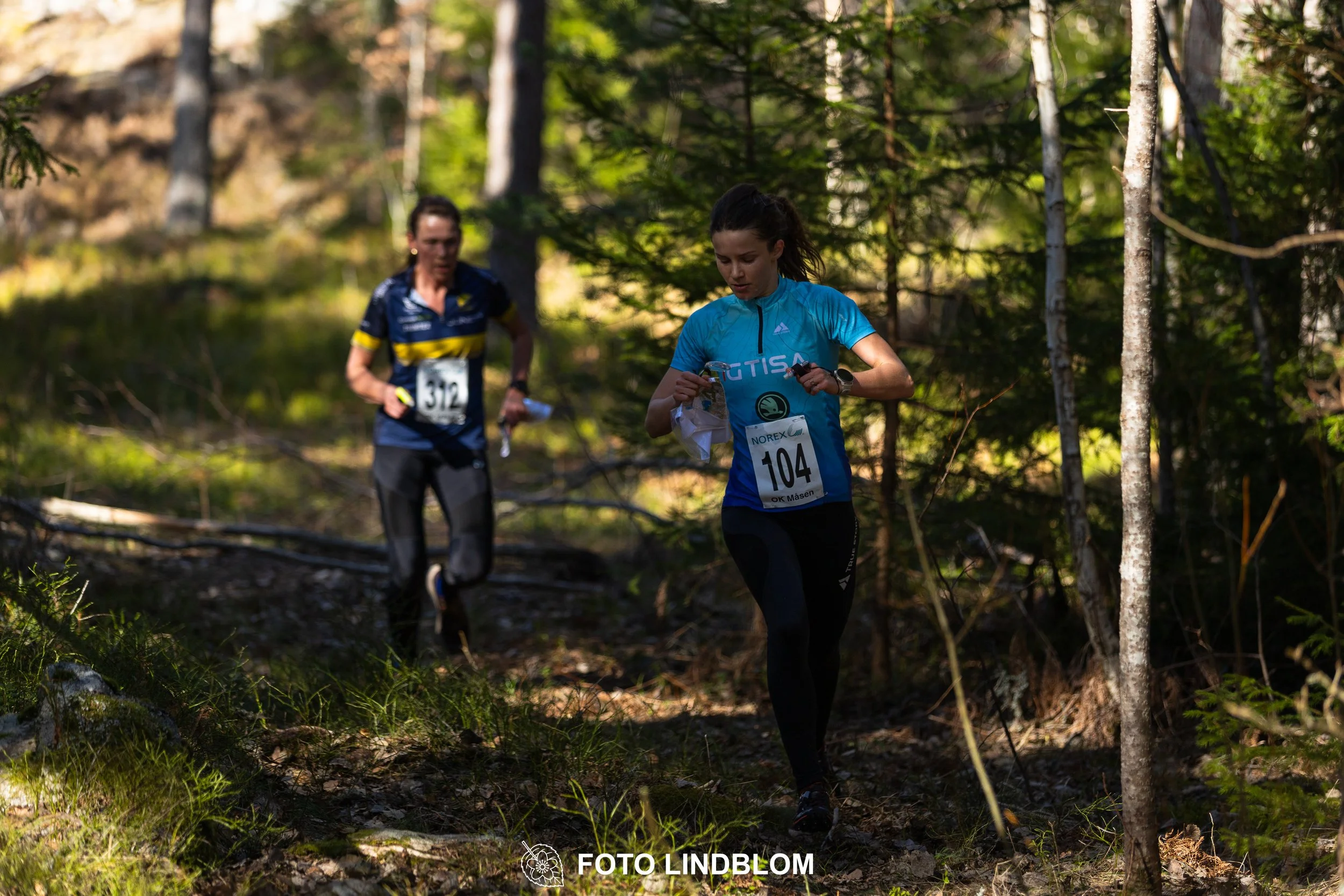 A relay-stage photo from Måsenstafetten 2026, featuring team-based orienteering competition, taken by Foto Lindblom.