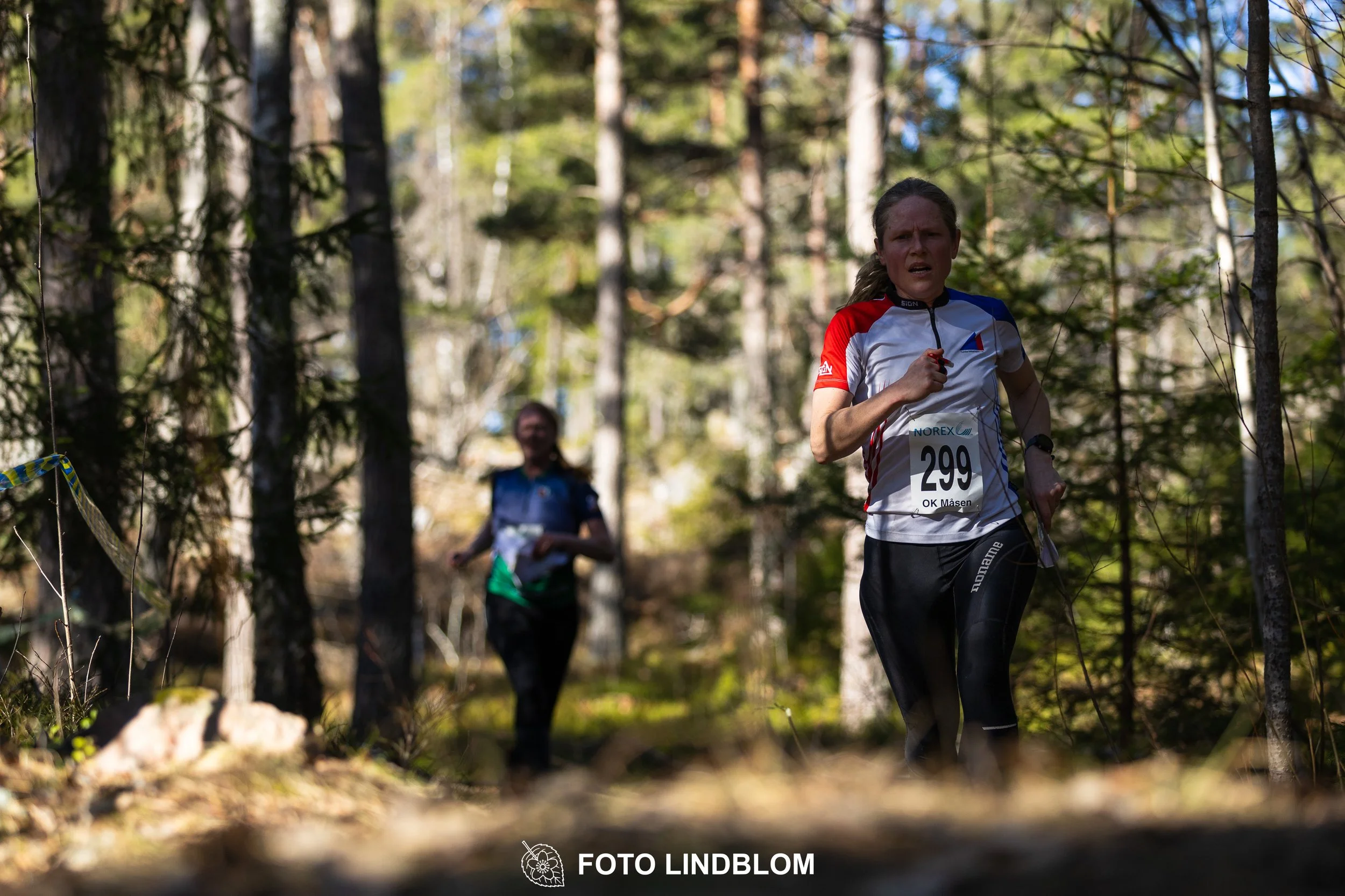 Swedish orienteering relay event Måsenstafetten 2026, with teams racing through forest terrain, captured by Foto Lindblom.