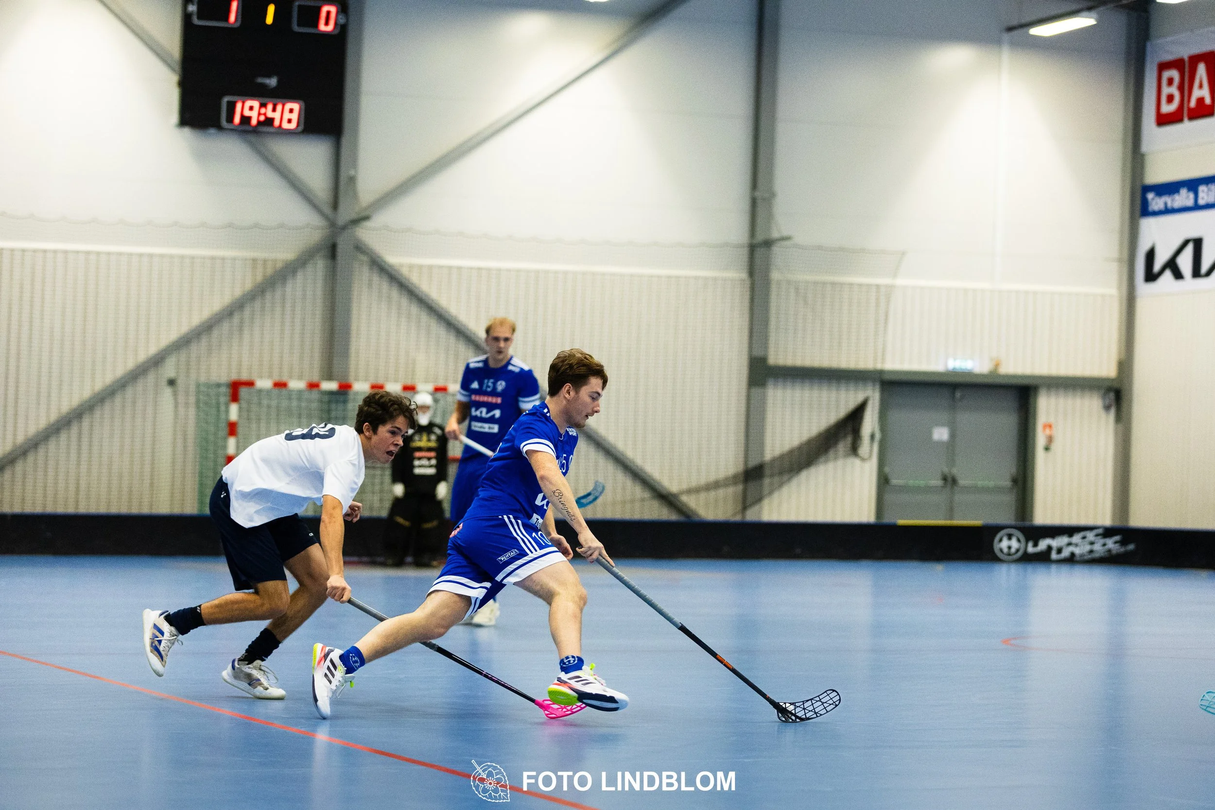 Images of people playing floorball wearing Värmdö IF and FBC Sollentuna team gear. 