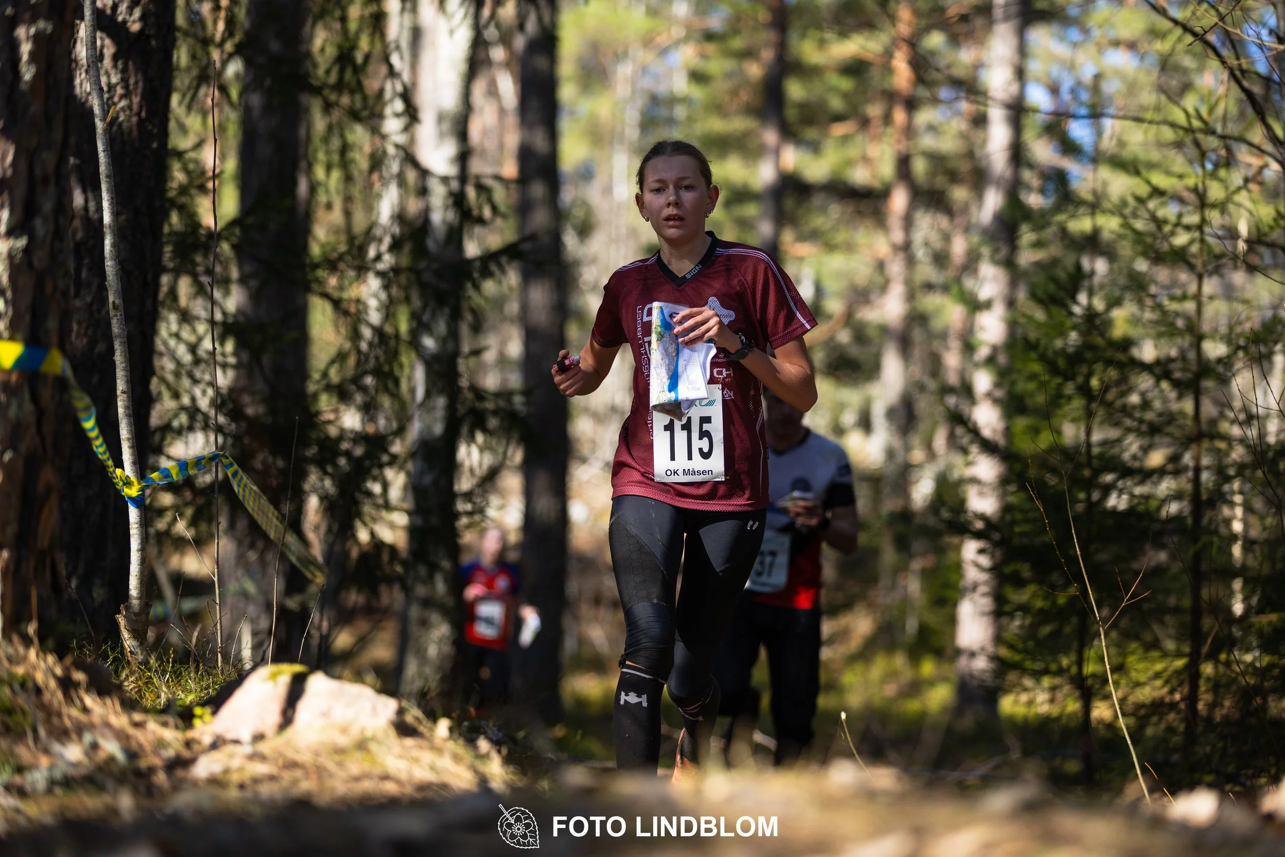 An image from the orienteering relay Måsenstafetten 2026, showing athletes in forest terrain, shot by Foto Lindblom.